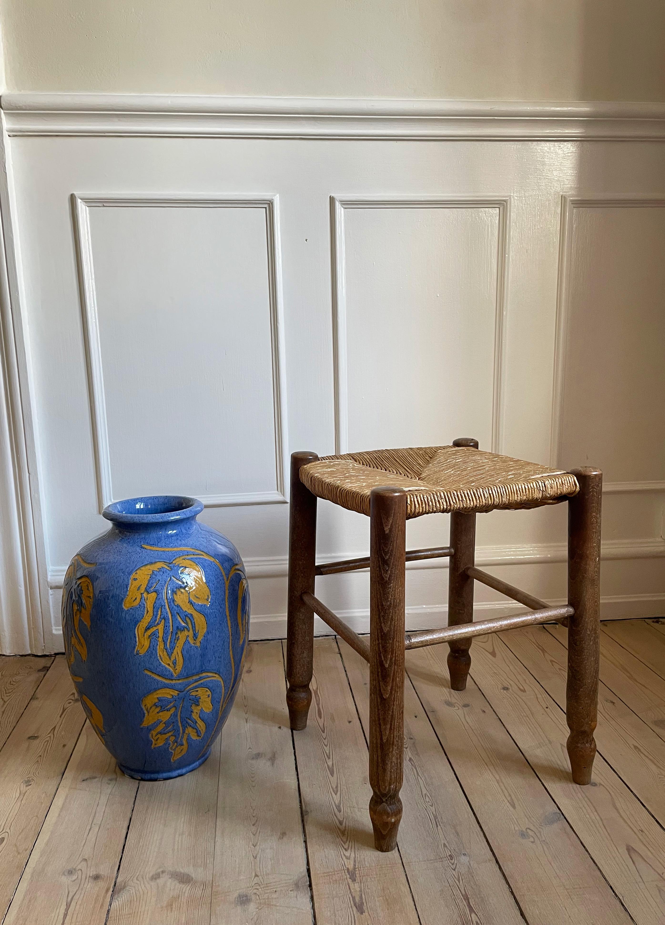 Tabouret vintage fait main en bois foncé avec assise en paille dans le style de Charlotte Perriand et Charles By. Belle condition vintage.
France, années 1950.