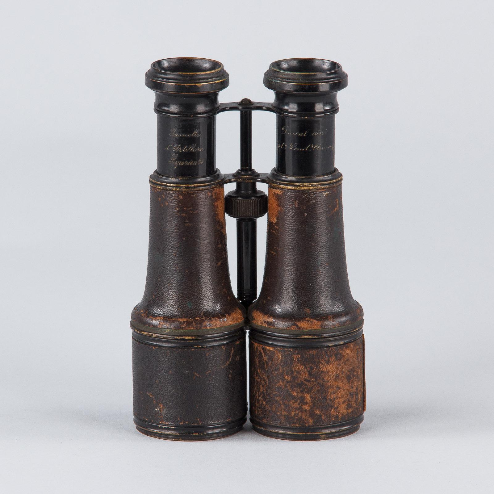 A Pair of WWI artillery binoculars by Duval Aine, optician in Annecy, France. The binoculars are in working order, they are made of metal and covered in black leather. A nice militaria collector's piece.
