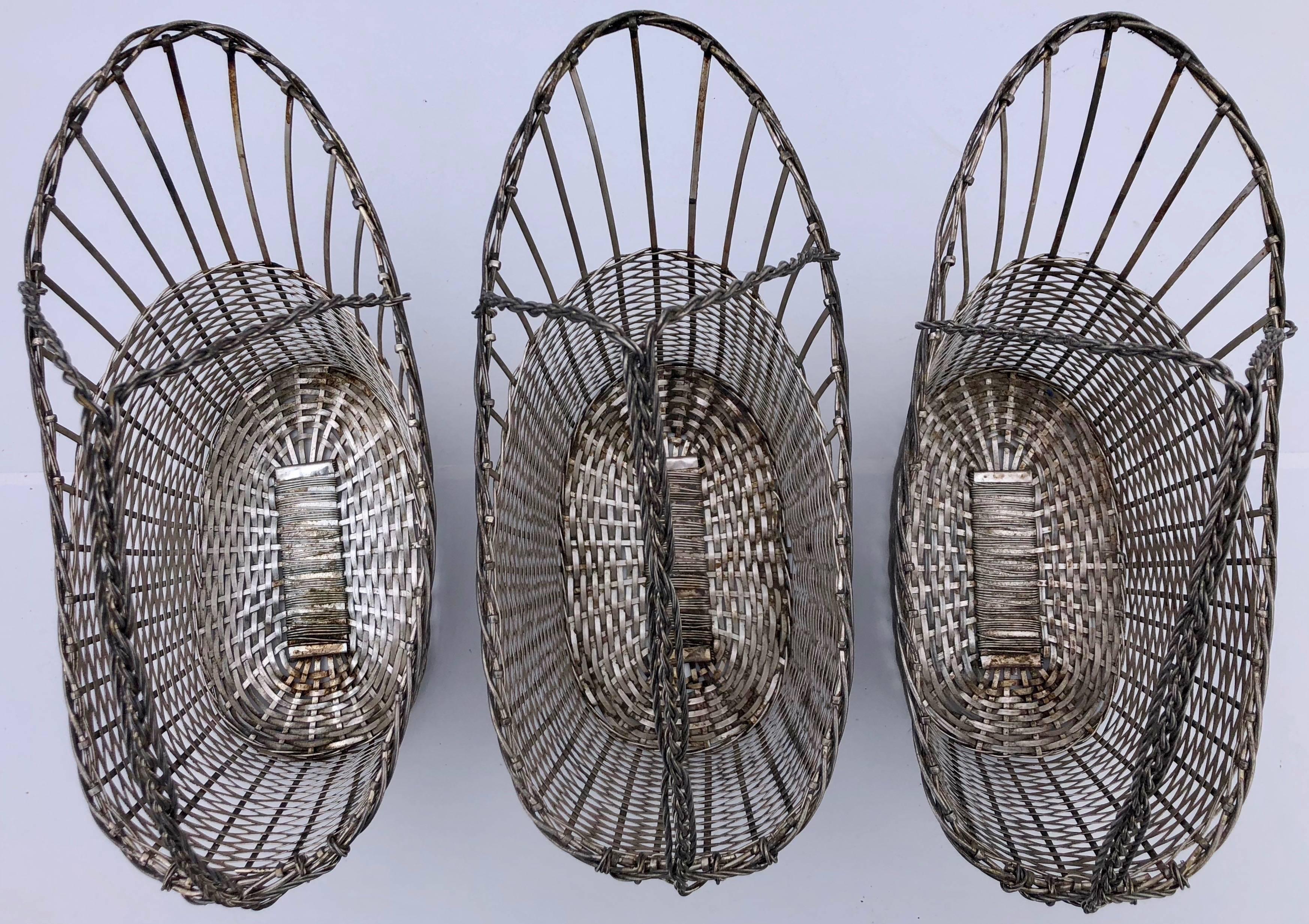 This set of three metal bottle baskets made of woven metal strips. They were used in a Parisian restaurant for decades and are very solid, yet very light, which is what one ideally needs when holding the basket in one hand to pour wine. A perfect
