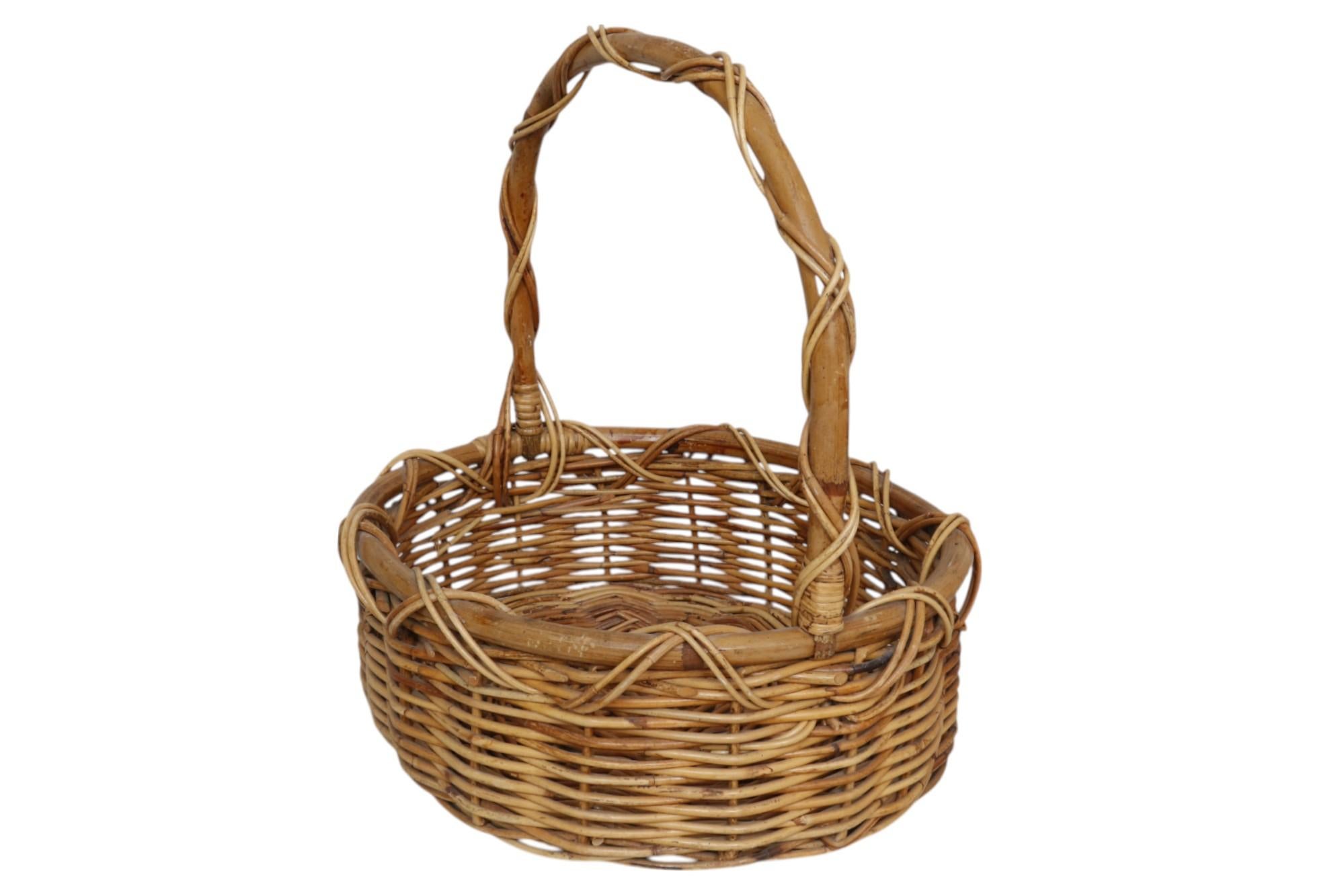 Una cesta de la compra o de recogida tradicional francesa hecha de mimbre tejido. Un asa arqueada de bambú curvado se envuelve con ratán decorativo entrecruzado, sujeto al borde de bambú de la cesta.