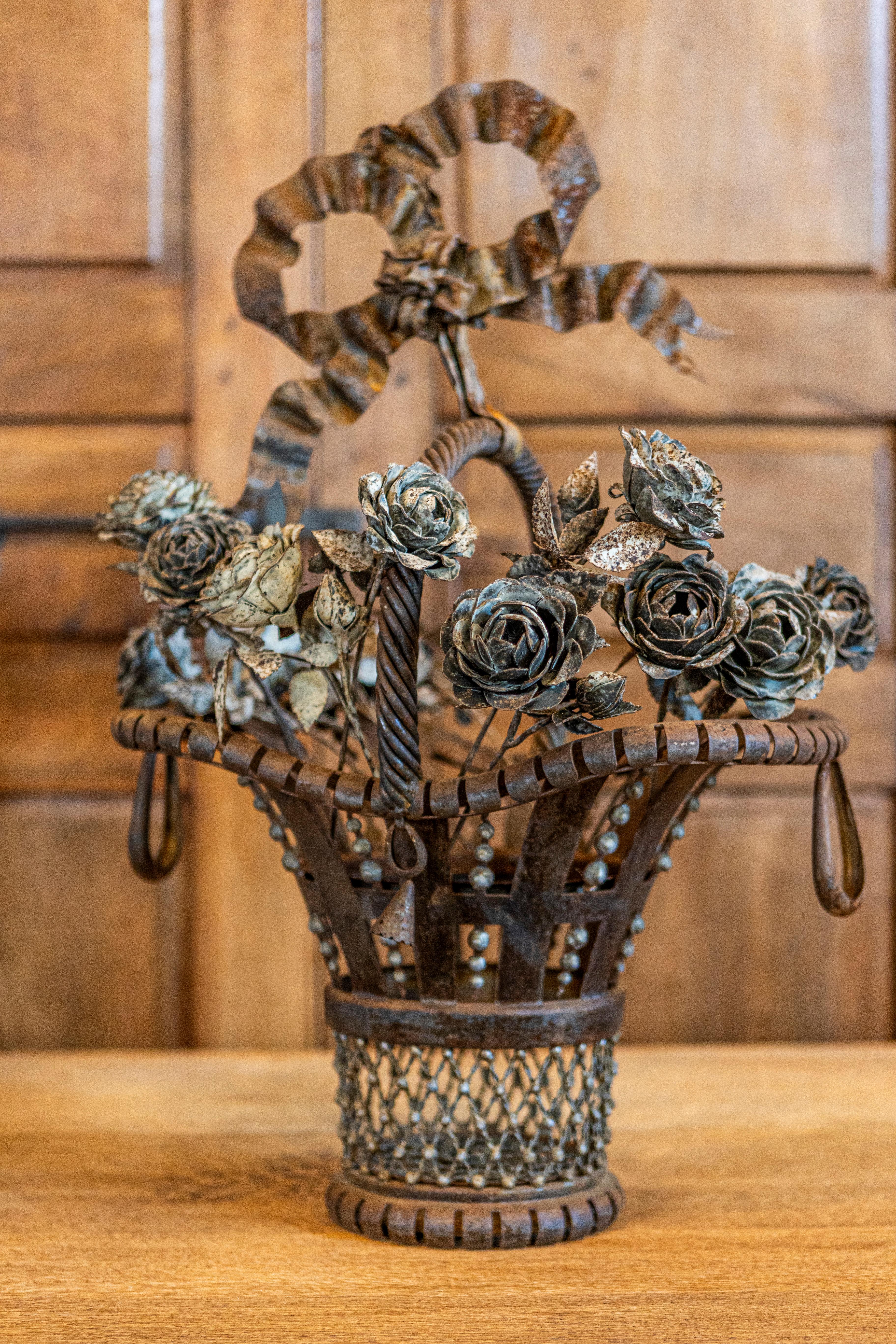 A French wrought iron decorative basket from the 19th century with Louis XVI ribbon, roses and rustic character. This 19th-century French wrought iron decorative basket is a beautiful testament to the elegance of Louis XVI design, blending timeless