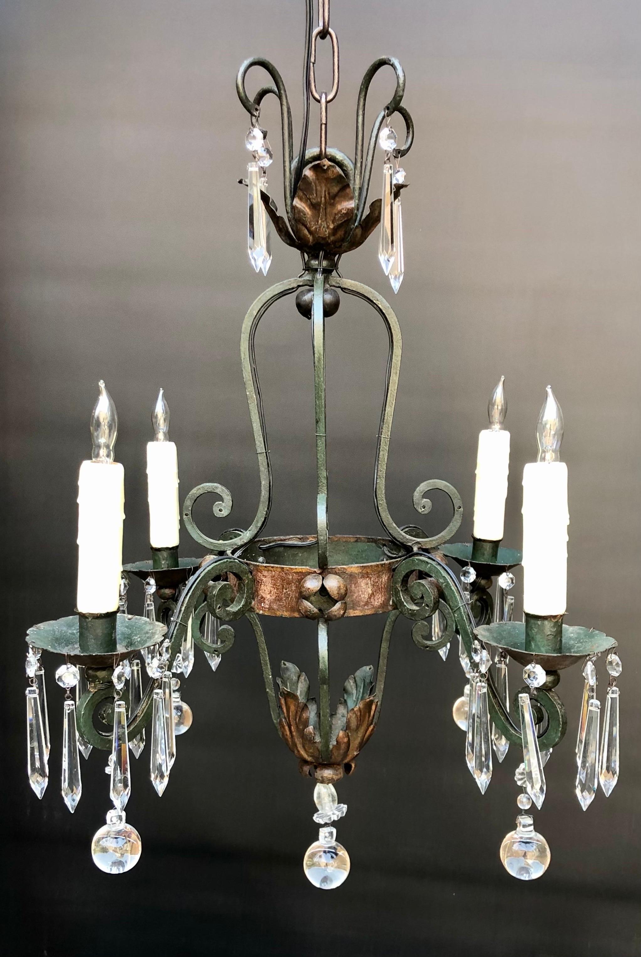 Elegant French wrought iron and crystal four arm chandelier with crystal icicle and ball prisms. The wrought iron has a dark Verde finish with dark bronze on the foliage.