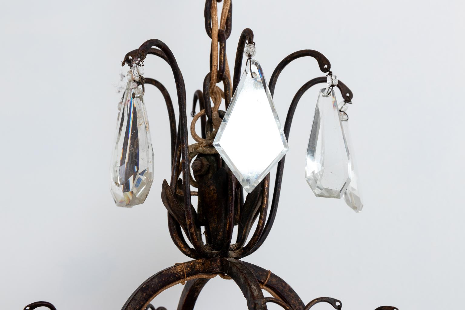 French chandelier made of wrought iron with a basket form filled with iron tracery, circa 1920s. The electrified arms are supported from the center basket. The fixture hangs from wrought iron supports. The basket and arms feature clear and amethyst