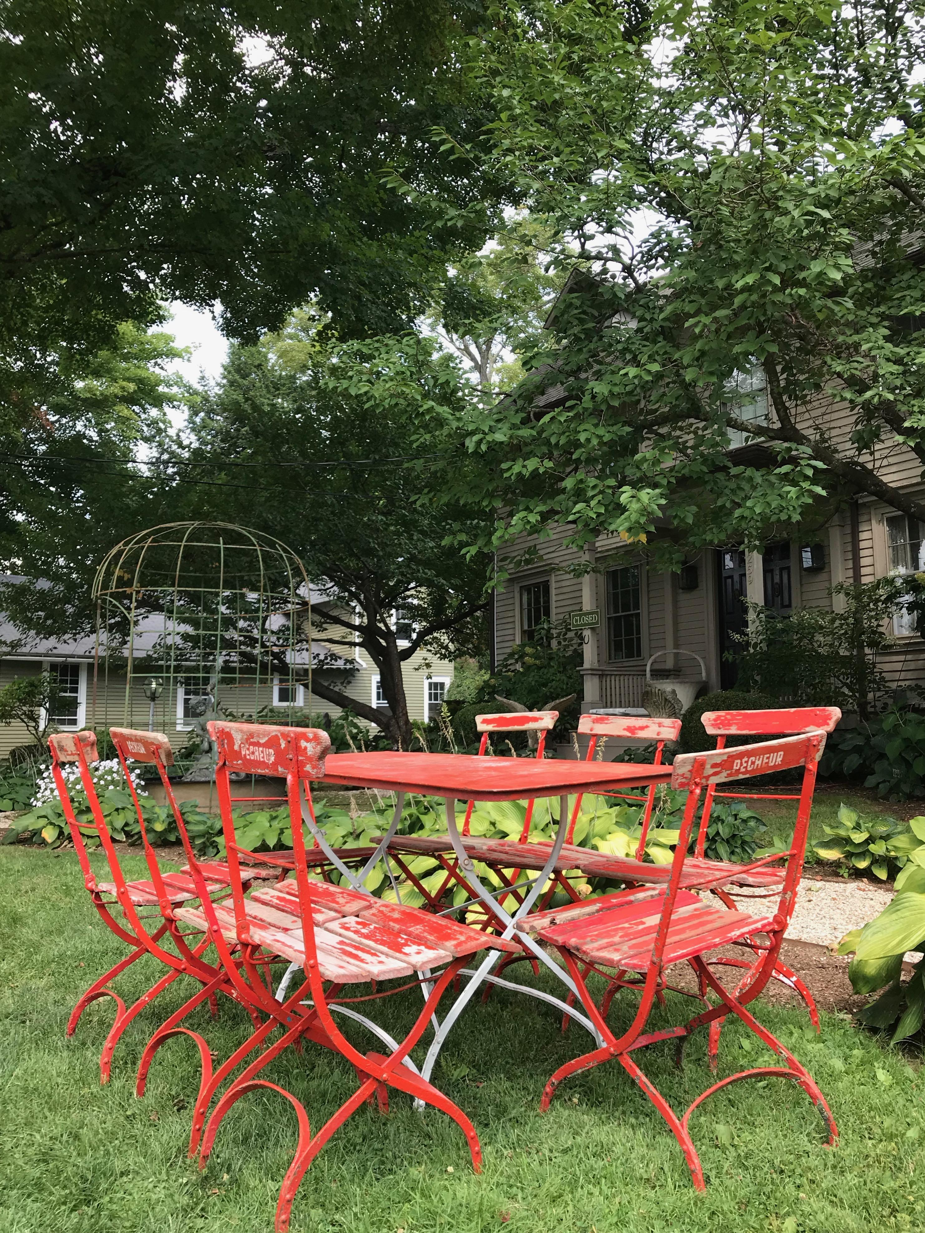 We usually don't go in for red, but this set is so outstanding in form, utility and patina, we couldn't resist. The chairs, most of which have a slight wobble to their legs from decades of use, are made of oak with all original riveting to the