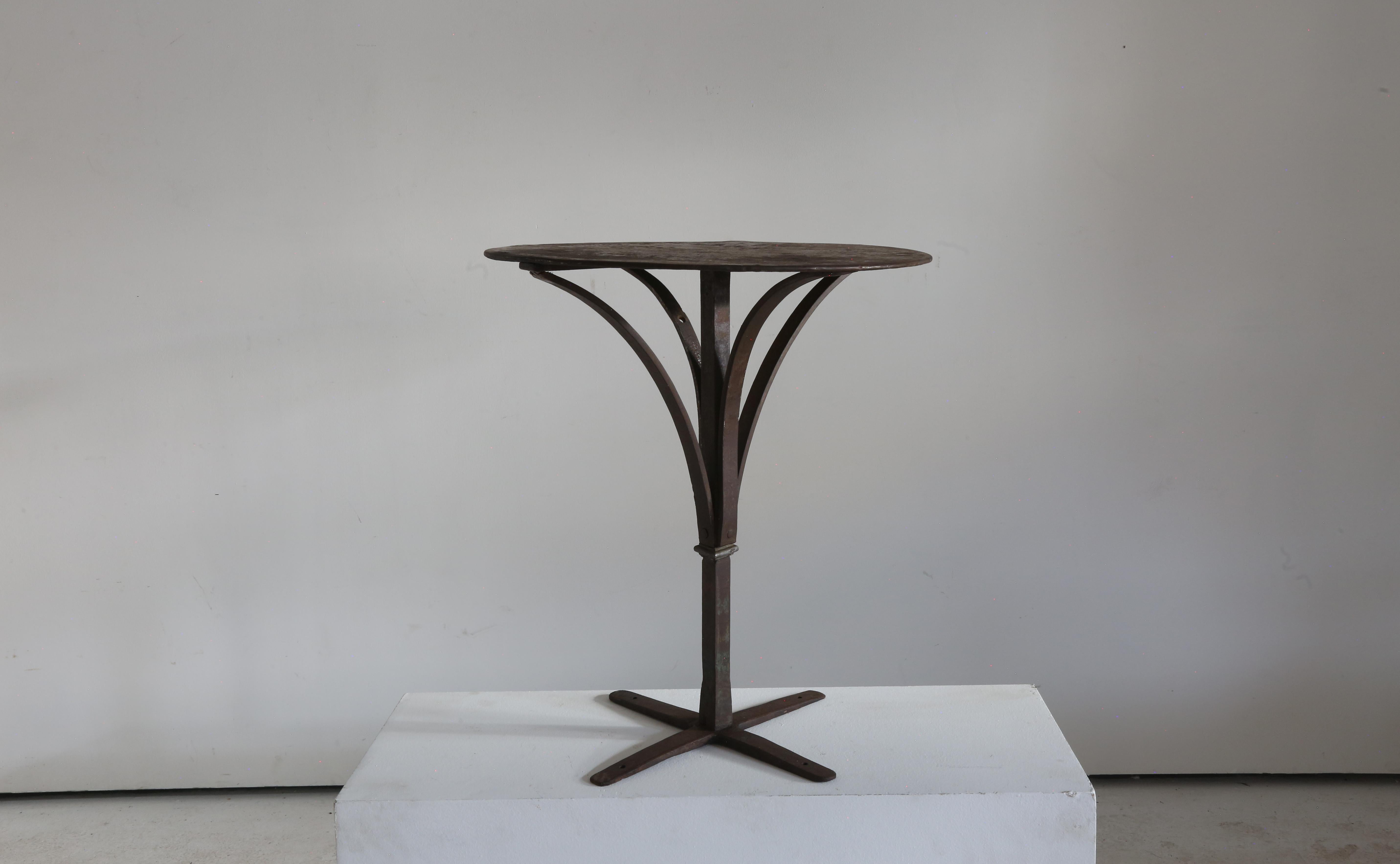 Stunning antique wrought iron and steel bistro table. 

Almost architectural in its design.975

Seriously weathered and patinated.  Now sympathetically renewed for another 100 years of usage.

Southern France 1920s. 