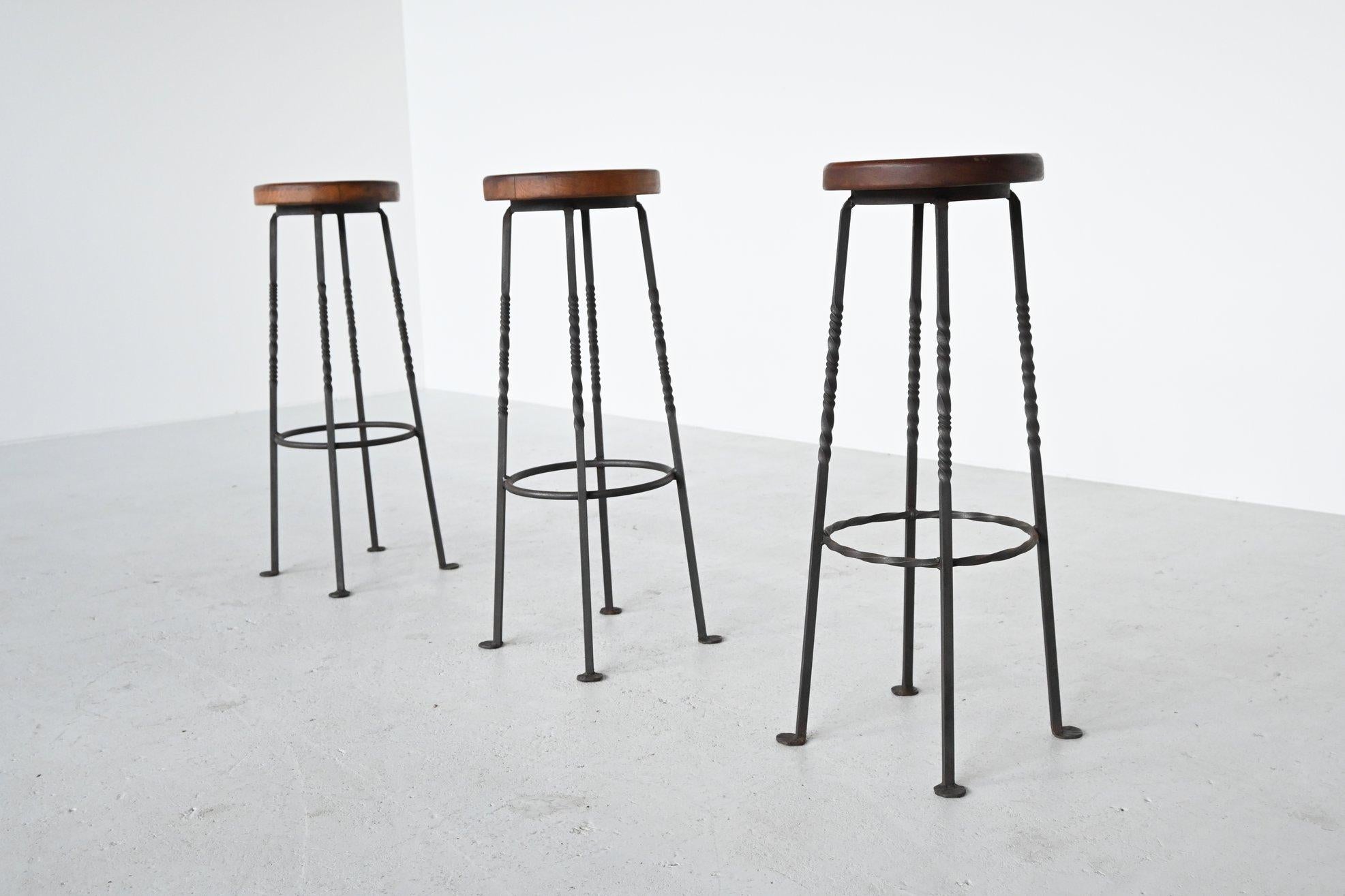Very nice set of 3 French iron bar stools by unknown designer and manufacturer, France 1960. These stools have a wrought iron frame and an ash wooden seat. A nice detail are the flattened feet. The stools are in good original condition and have a