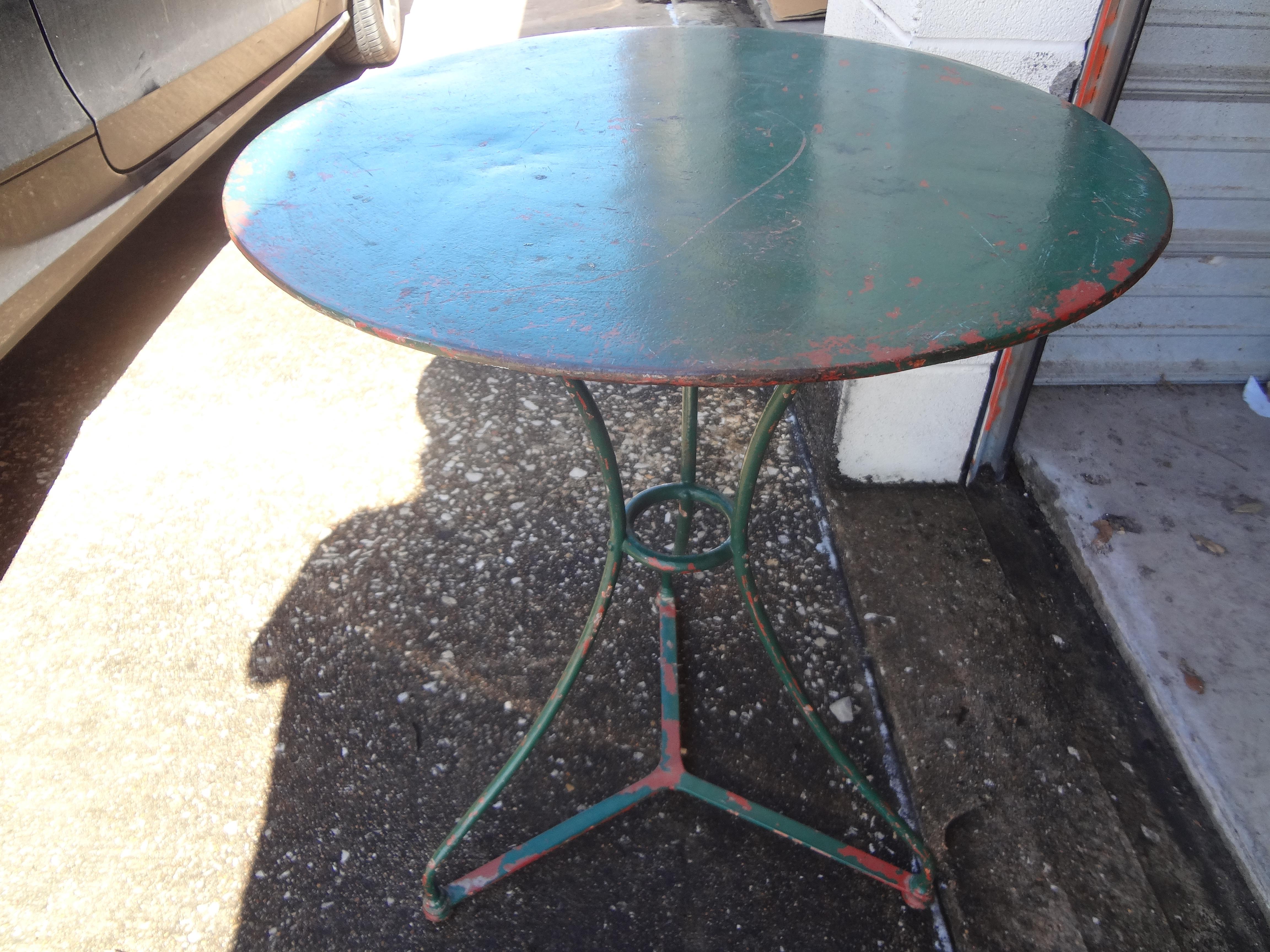 Great round antique French wrought iron bistro table, cafe table or garden table. This French iron table is a lovely shade of green with previous paint showing through. Our versatile French iron table can be used as a side table or guéridon indoors