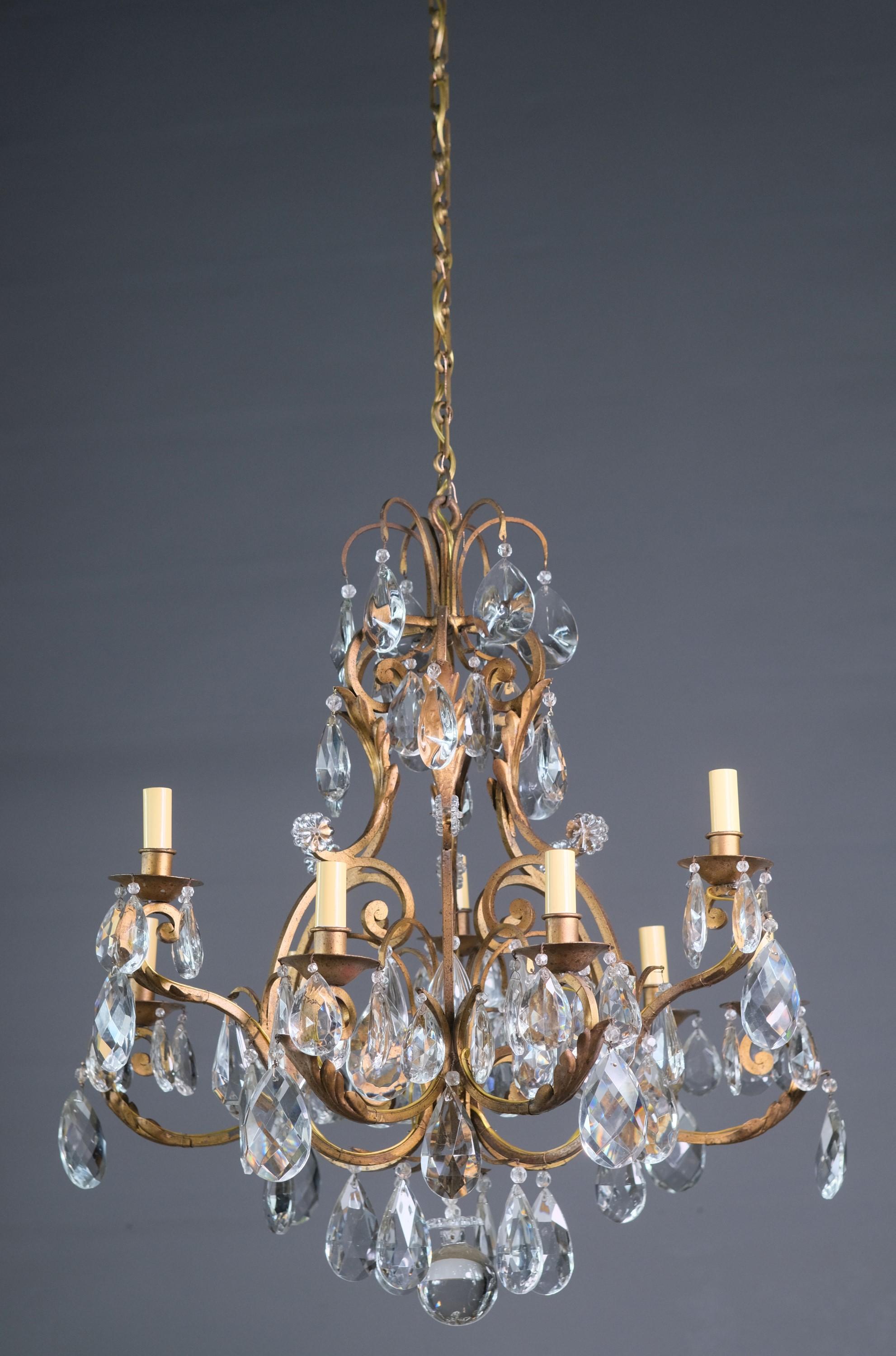 20th century French chandelier that has been cleaned and restored. Wrought iron with nine lights. Beautiful crystals drip everywhere. Please note, this item is located in one of our NYC locations.