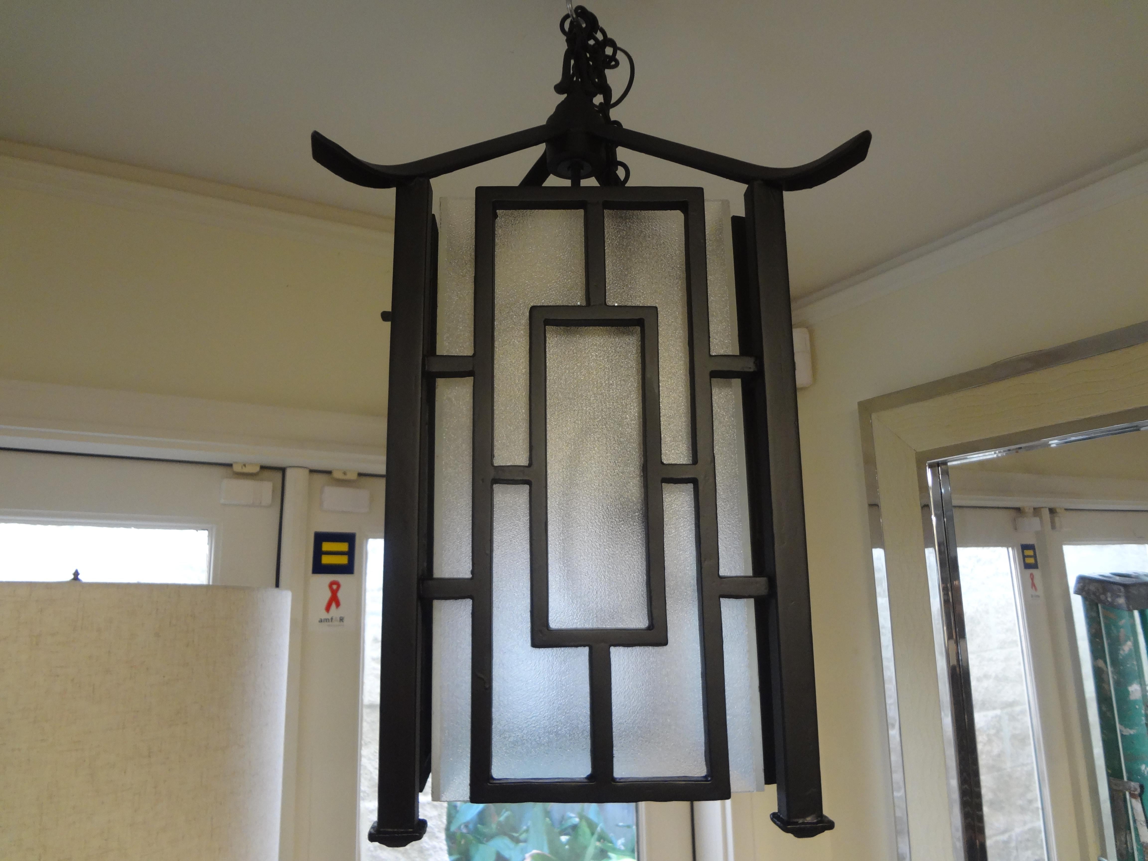 Stunning French wrought iron Chinese Chippendale style pagoda lantern. This heavy duty hand forged black wrought iron pagoda shaped lantern has been newly wired to U.S. specifications with its original chain.