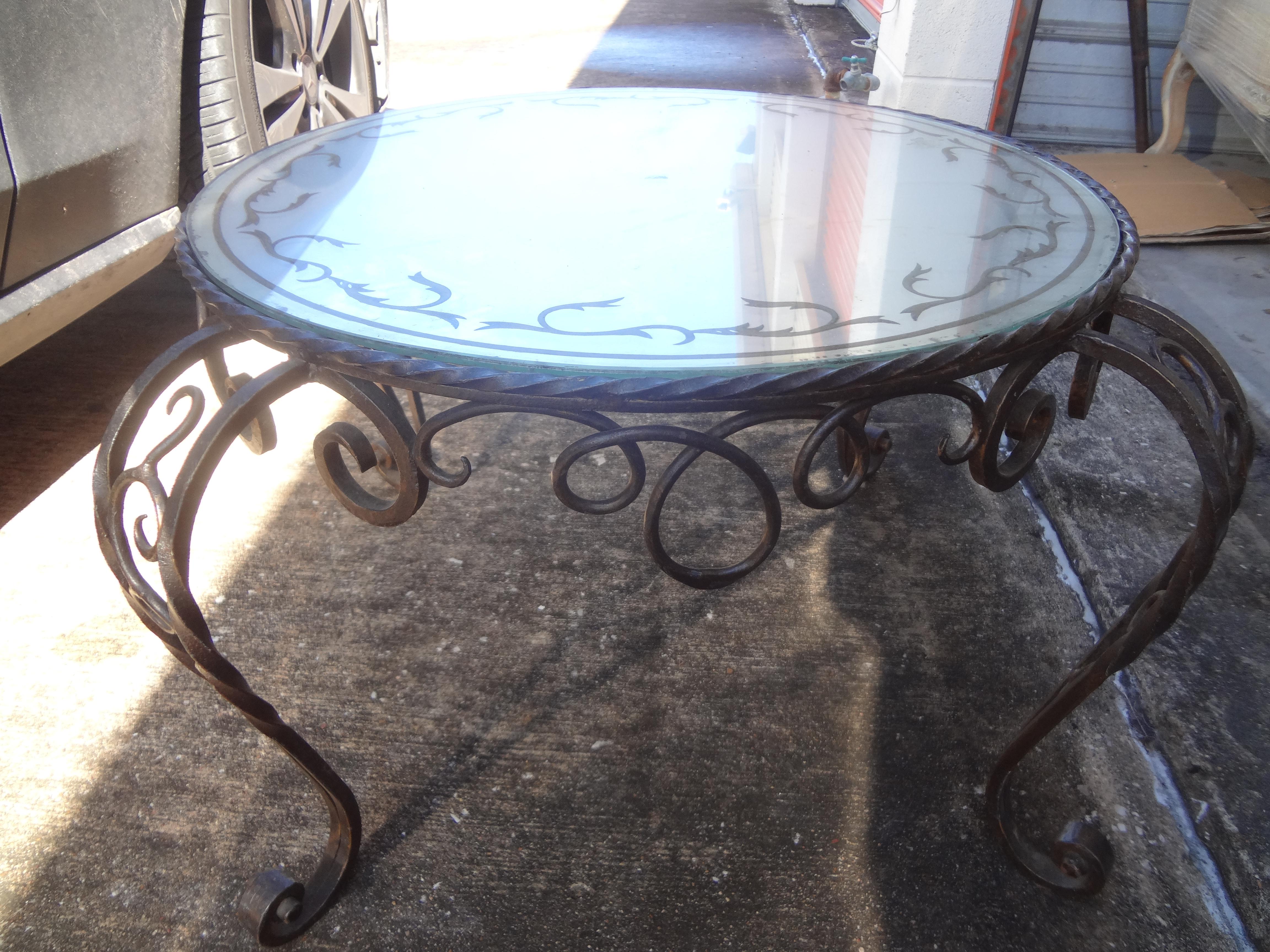 French wrought iron cocktail table with Églomisé Top.
Great French 1940s round hand forged wrought iron cocktail table or coffee table with gilt decorated eglomise top.
The églomisé (reverse decorated) mirrored top has light wear, but no chips or