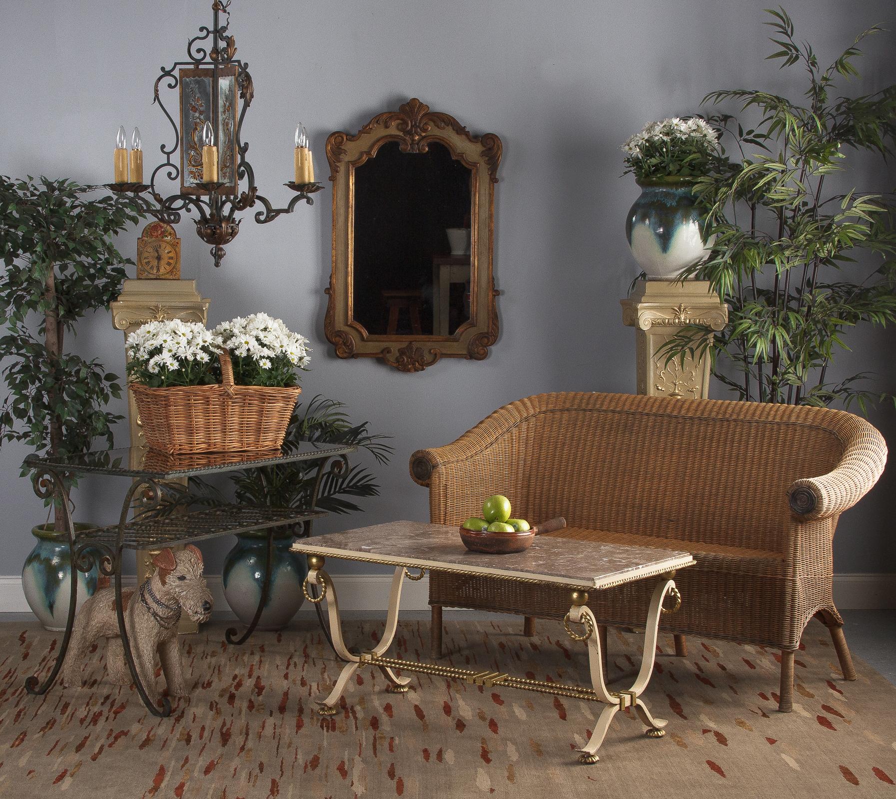 A decorated vintage wrought iron and smoked glass table with shelf, French, circa 1940. Handwrought iron frame with copious scrolls and tight twists supporting a rectangular smoked glass top. The legs are long, symmetrical scrolls joined by smaller