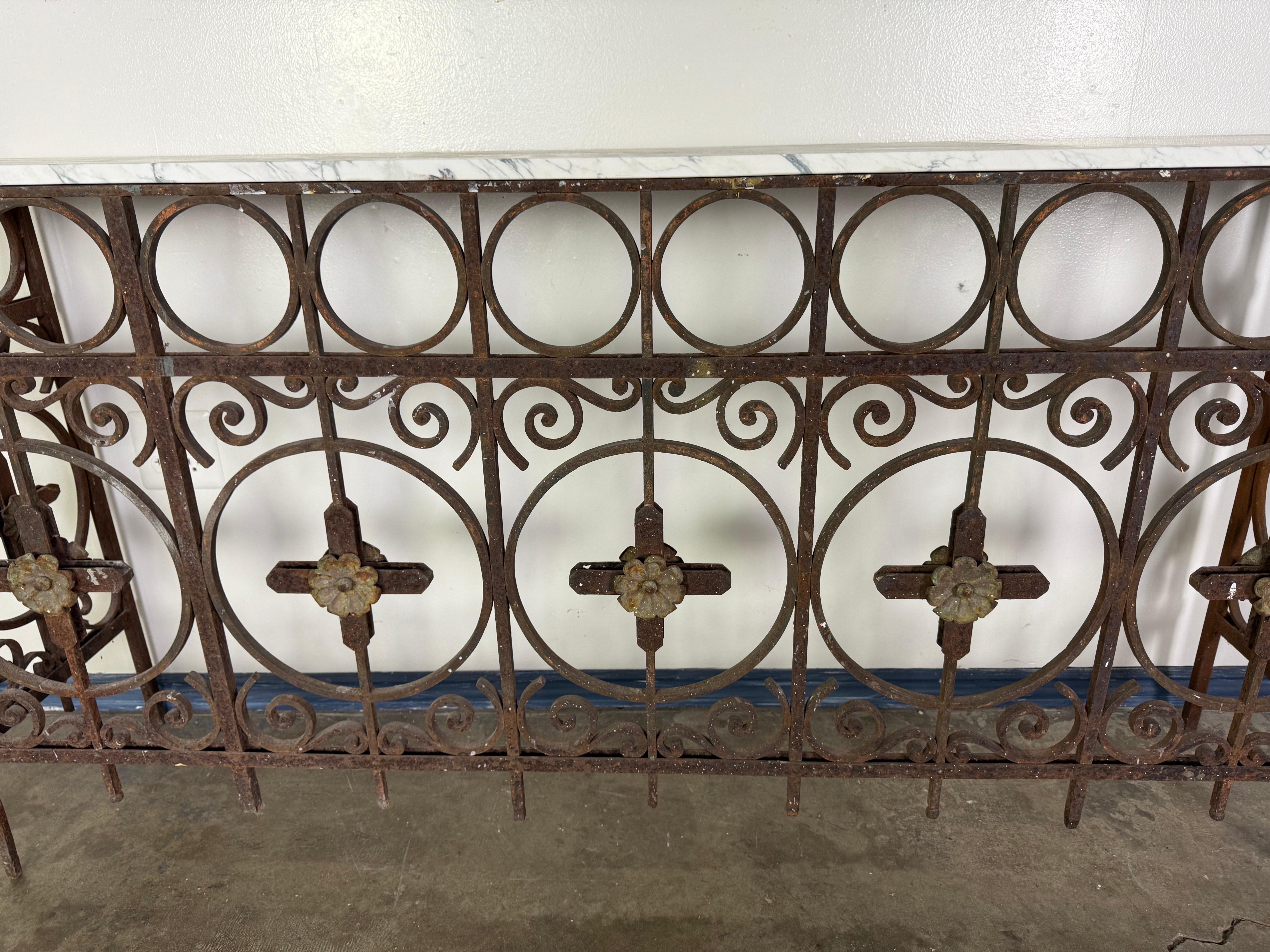 This striking 19th century French wrought iron console features an ornate base repurposed from antique architectural ironwork, likely originating in Provence or the Languedoc region. Crafted in the Neoclassical style, the design showcases graceful