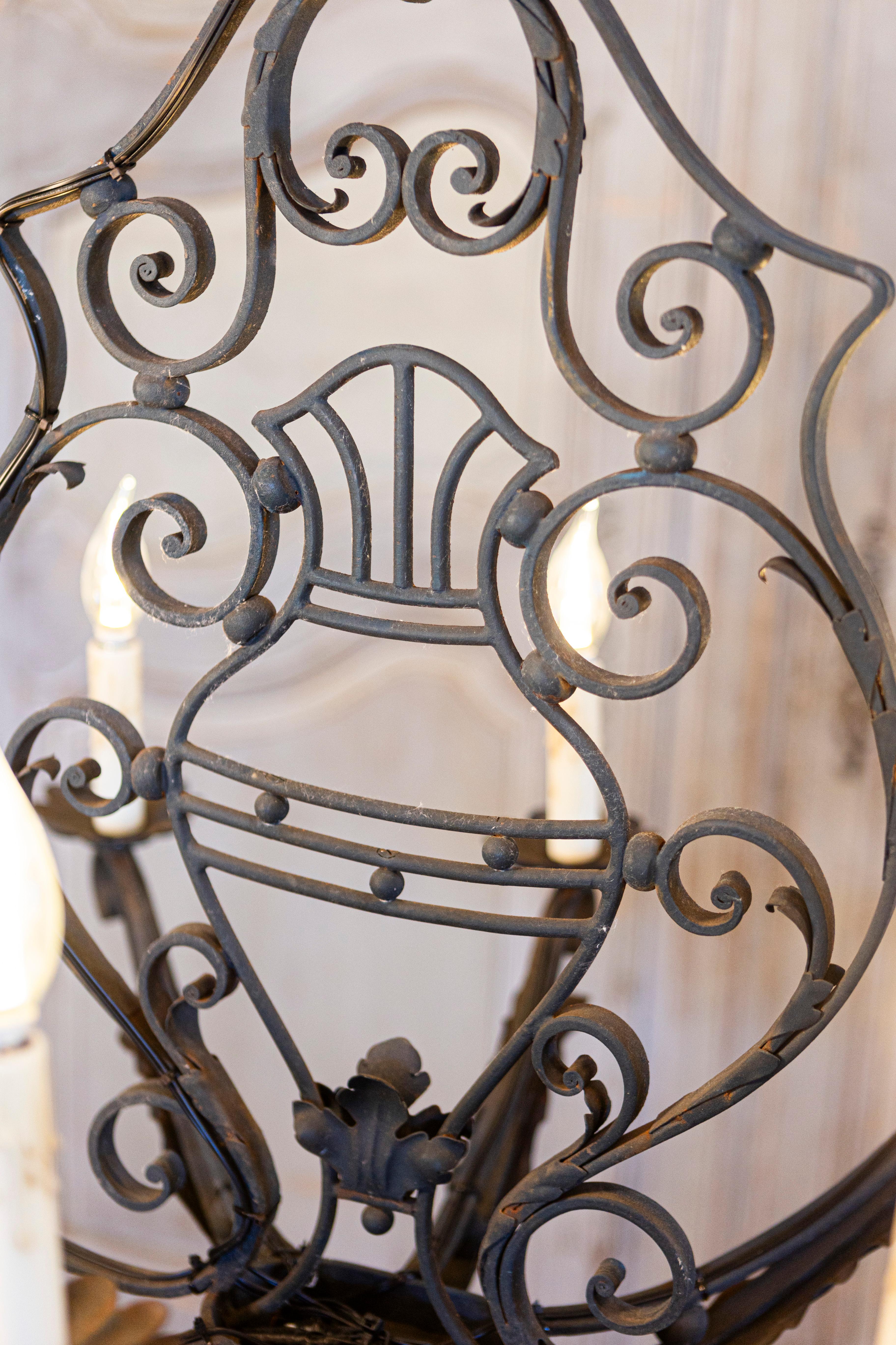 Français Lustre à huit lumières en fer forgé français avec motifs de volutes, USA câblé en vente