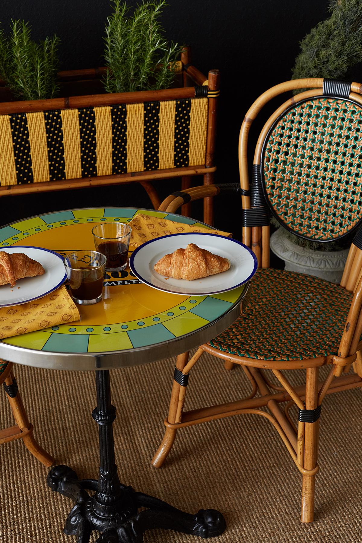 Colorful cafe bistro table made in the French Art Deco style featuring an enamel top. Decorated with the Cafe Society of San Francisco's Eiffel tower logo with wings and the quote 