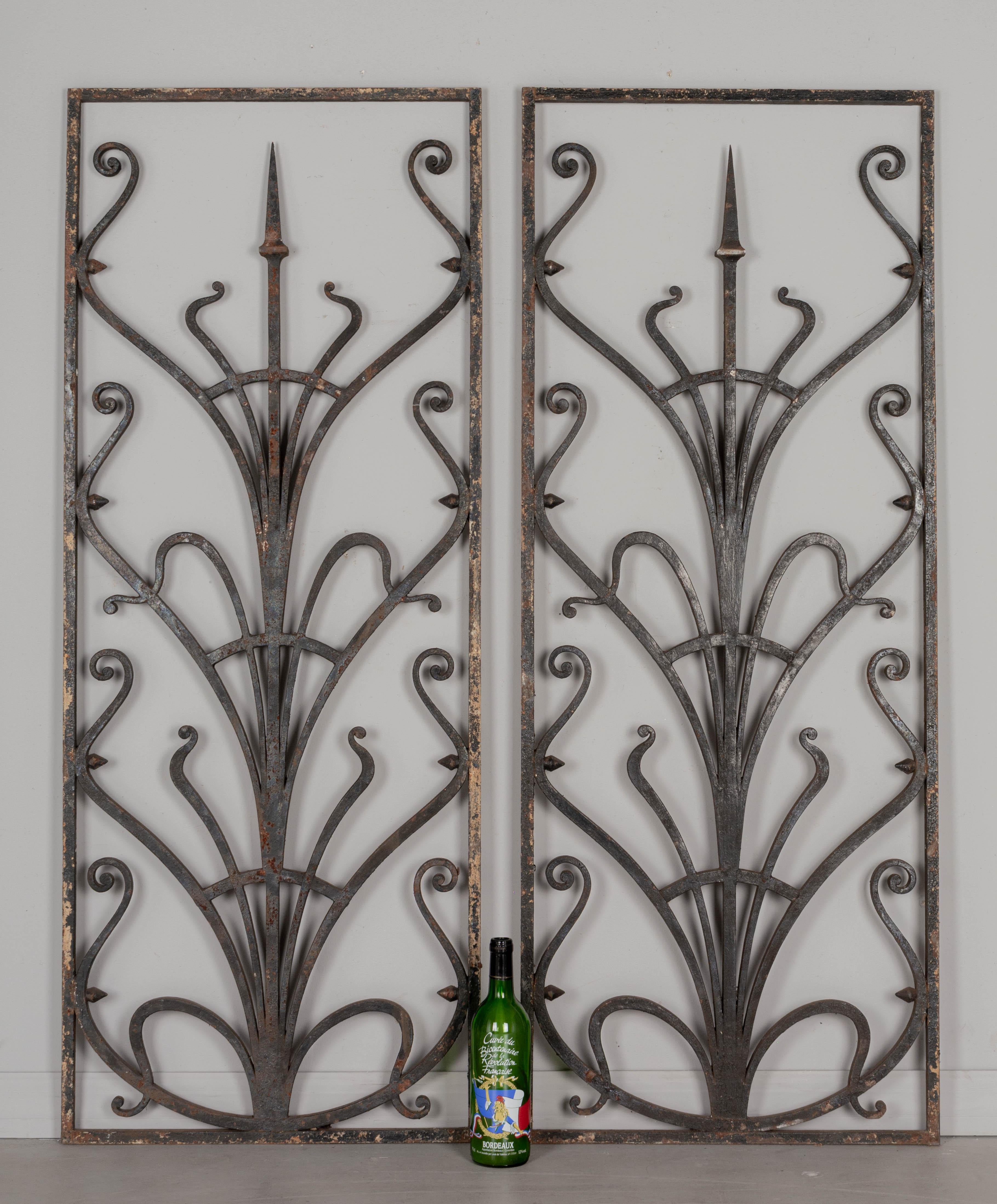 A pair of French Art Nouveau wrought iron garden gate grilles or decorative panels with dark painted patina. Good quality iron work. Some rust and peeling paint. Please refer to photos for more details. Pictures are part of the description. Circa
