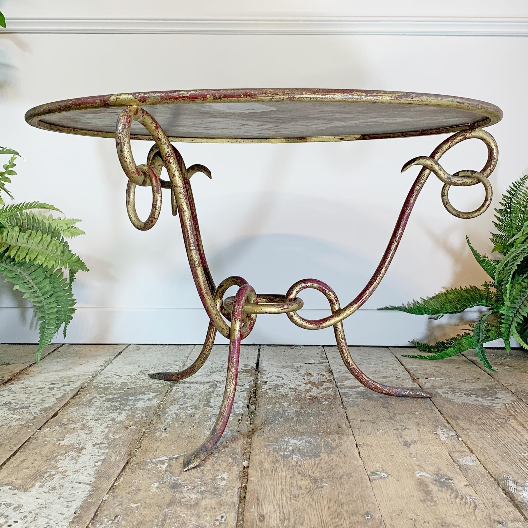 Exceptionnelle table basse en fer forgé doré avec plateau en tôle miroir vieillie du célèbre designer René Drouet 1899 -1993. 

La lourde base en fer forgé, avec des détails en anneau et un bole visible sous la dorure des pieds et des bords,