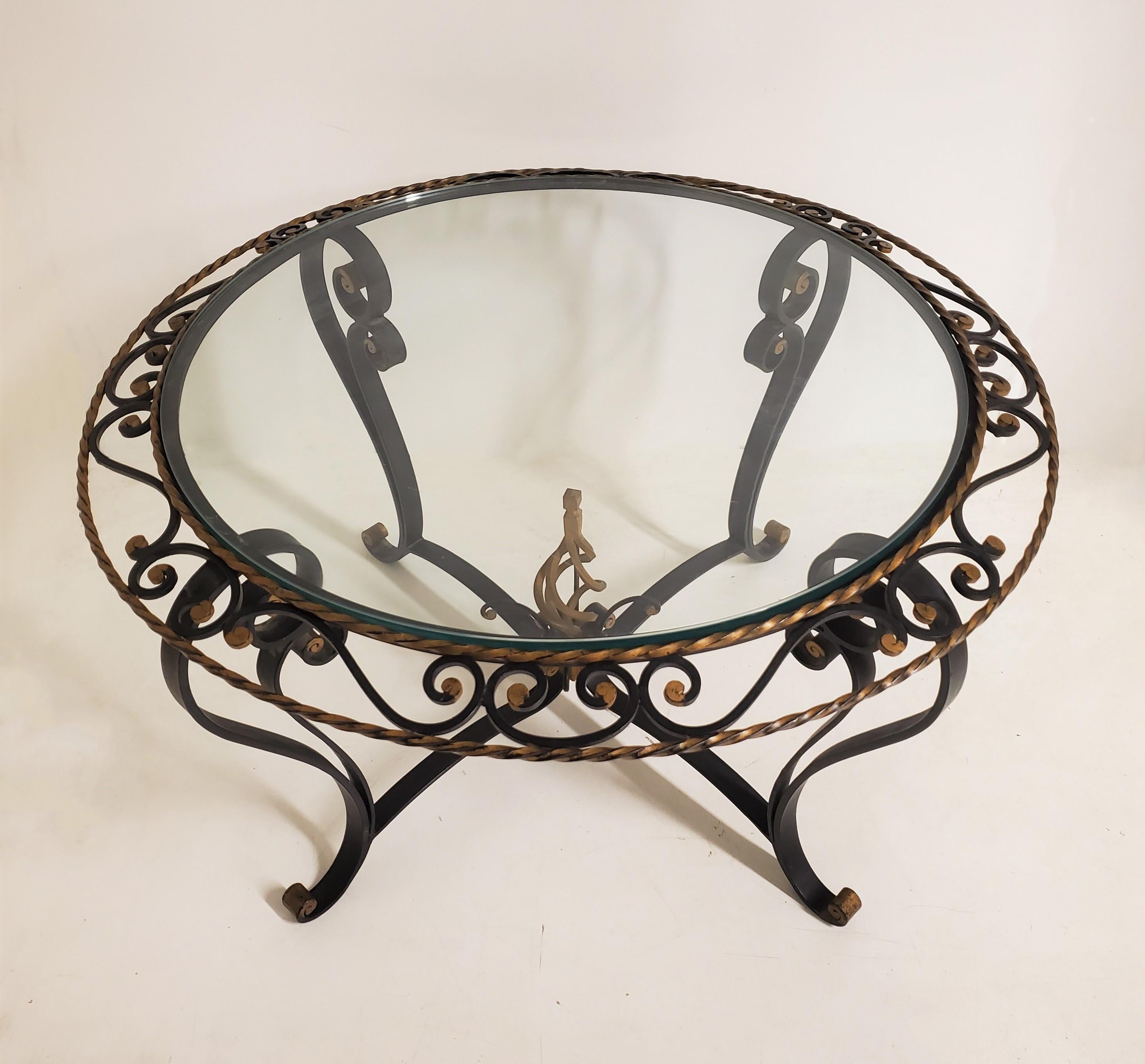 A French Art Deco circular coffee table expertly crafted in hand forged iron and finished in tones of gold and black, attributed to Poillerat 
The combination of the two colors creates a beautiful contrast to enhance any living space. The table