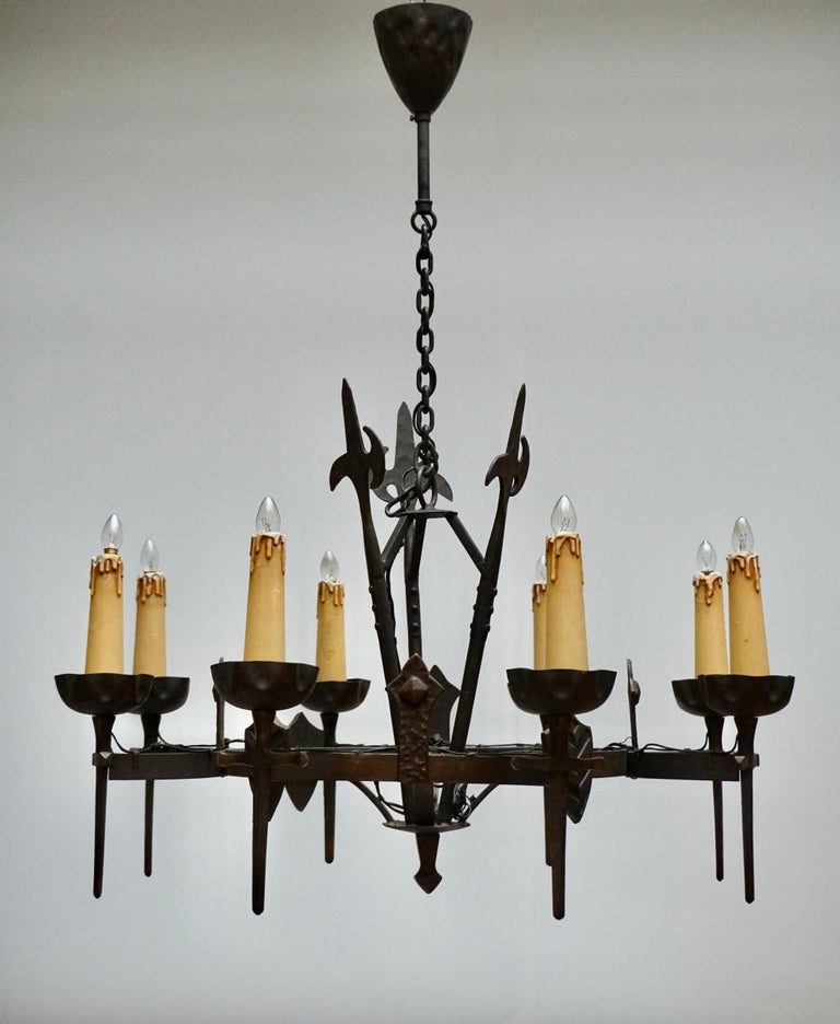 French wrought iron eight-light chandelier with decorative lances and shields. Originally candle powered.
Measures: Diameter 76 cm.
Height fixture 53 cm.
Total height with chain 100 cm.
Weight 9 kg.