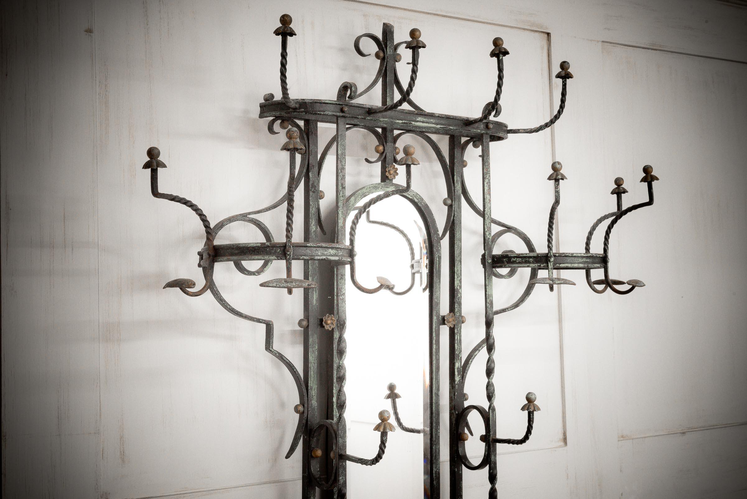 French wrought iron hall stand with coat and hat hooks, a central mirror with a small drawer for keys and watches.