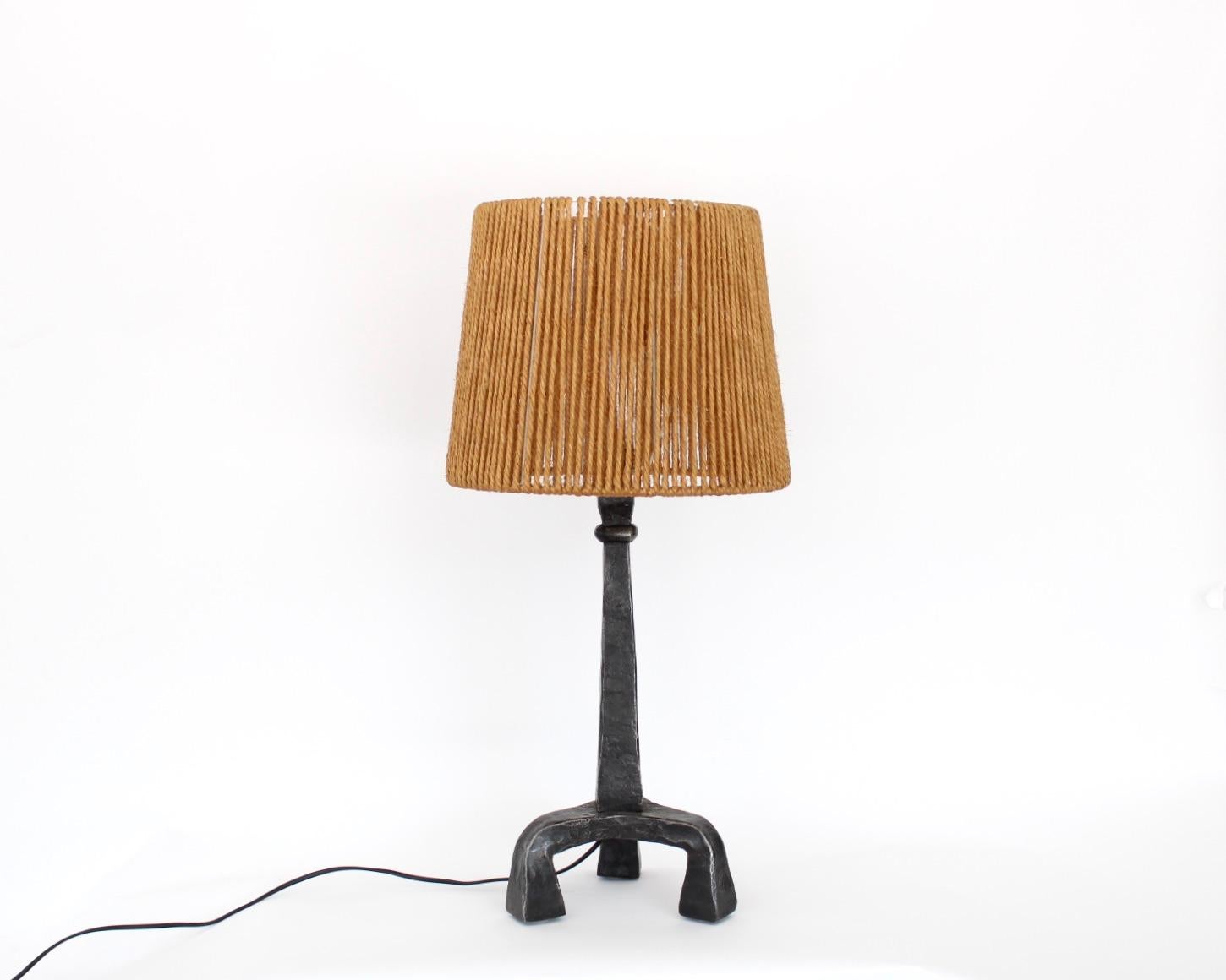 Hand hammered or Fer Battu French wrought iron table lamp with original French string shade. 
In the manner or Ateliers Marolles. 
Wonderful original French string shade made of sisal in excellent condition,. 
Rewired to retain the original shade