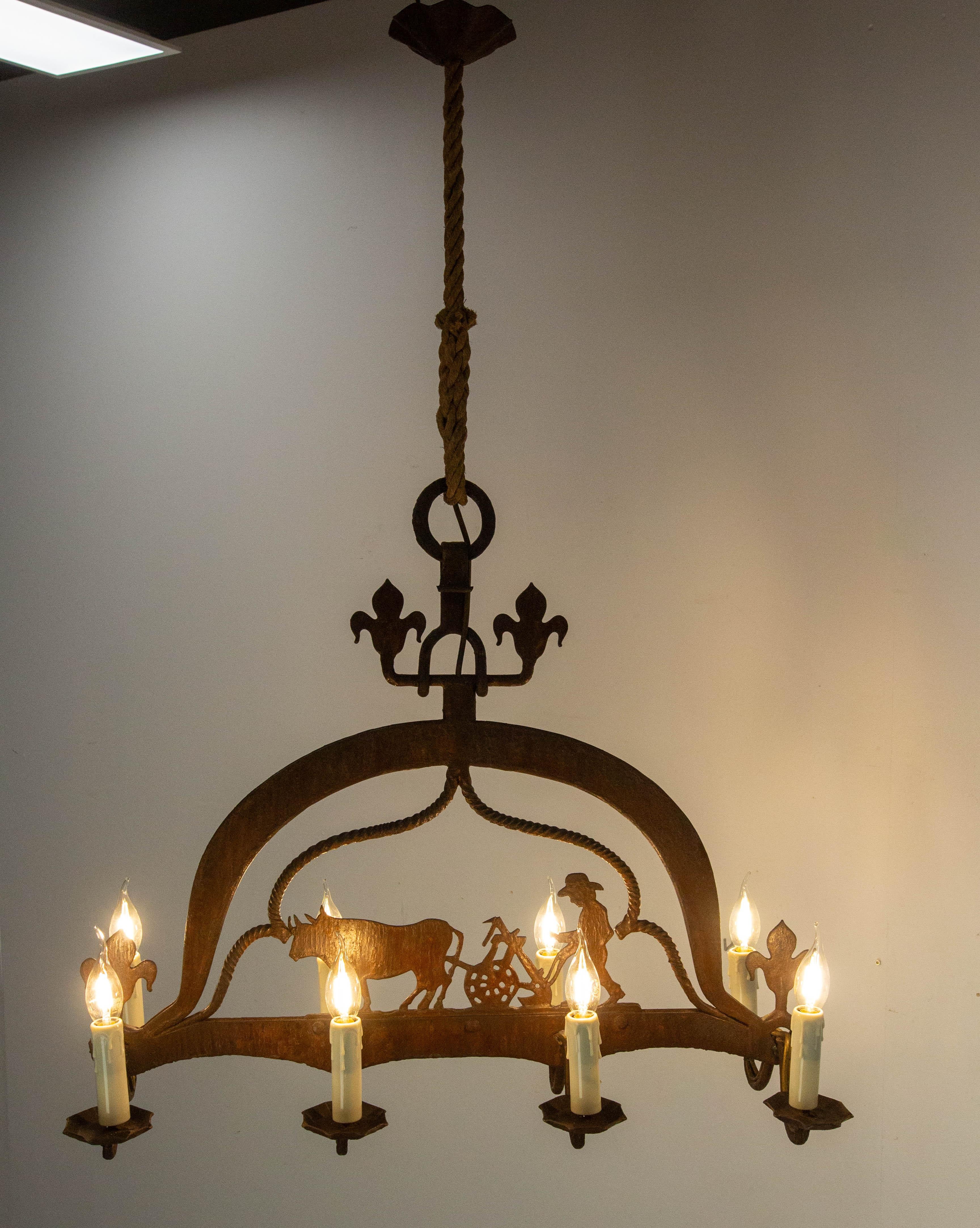 Pendente da soffitto in ferro battuto sorretto da una robusta corda.
Lustro che rappresenta una scena agricola: un contadino che ara il suo campo con la sua coppia di buoi.
Quattro fleur-de-lis sormontano e incorniciano la scena.
Francese, circa