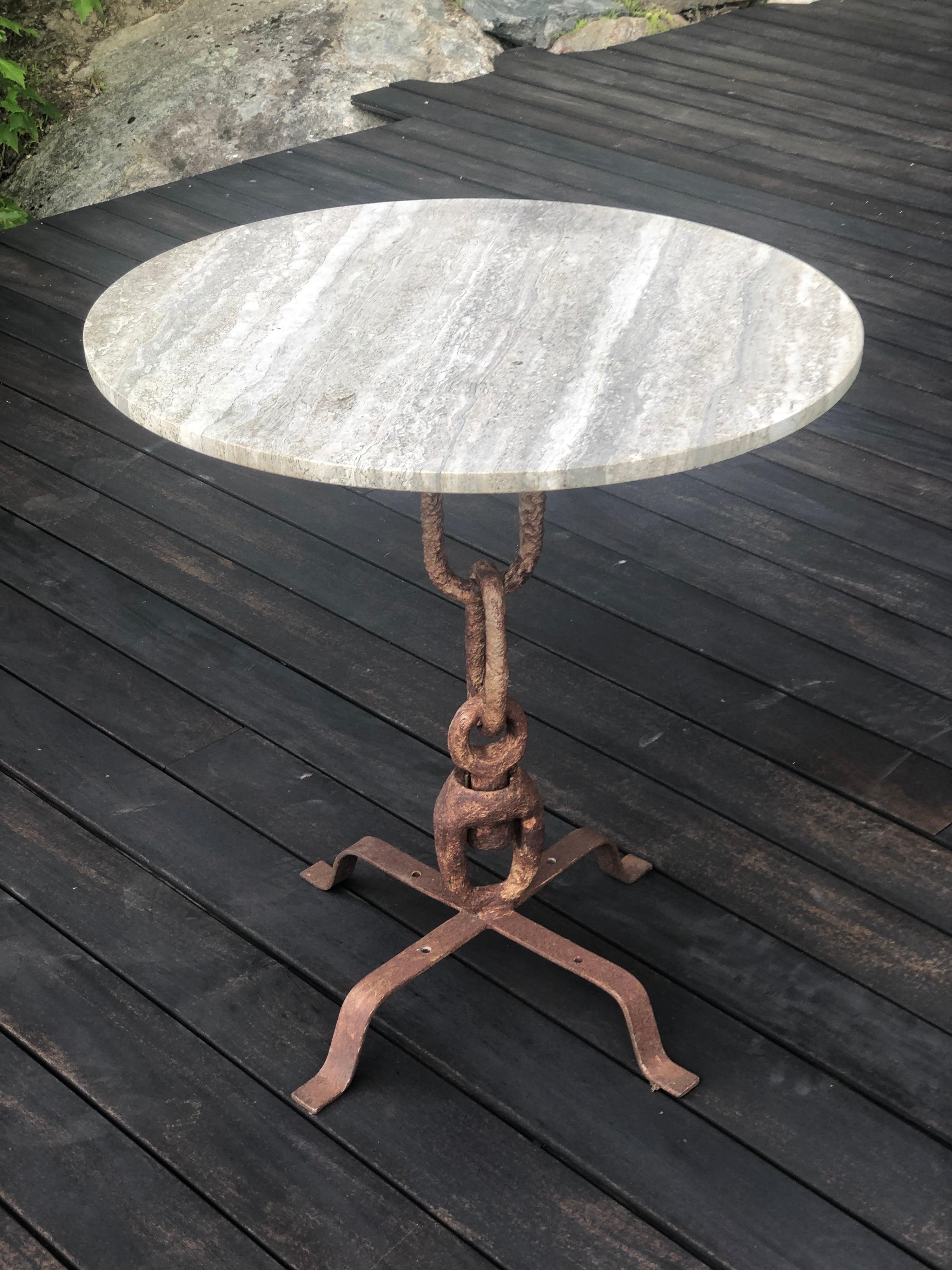 An elegant French mid-century hand wrought iron & silver travertine dining / garden table reminiscent of Alberto and Diego Giacometti circa 1940. The piece combines ancient forms and the modern in a startling dialogue that was characteristic of the