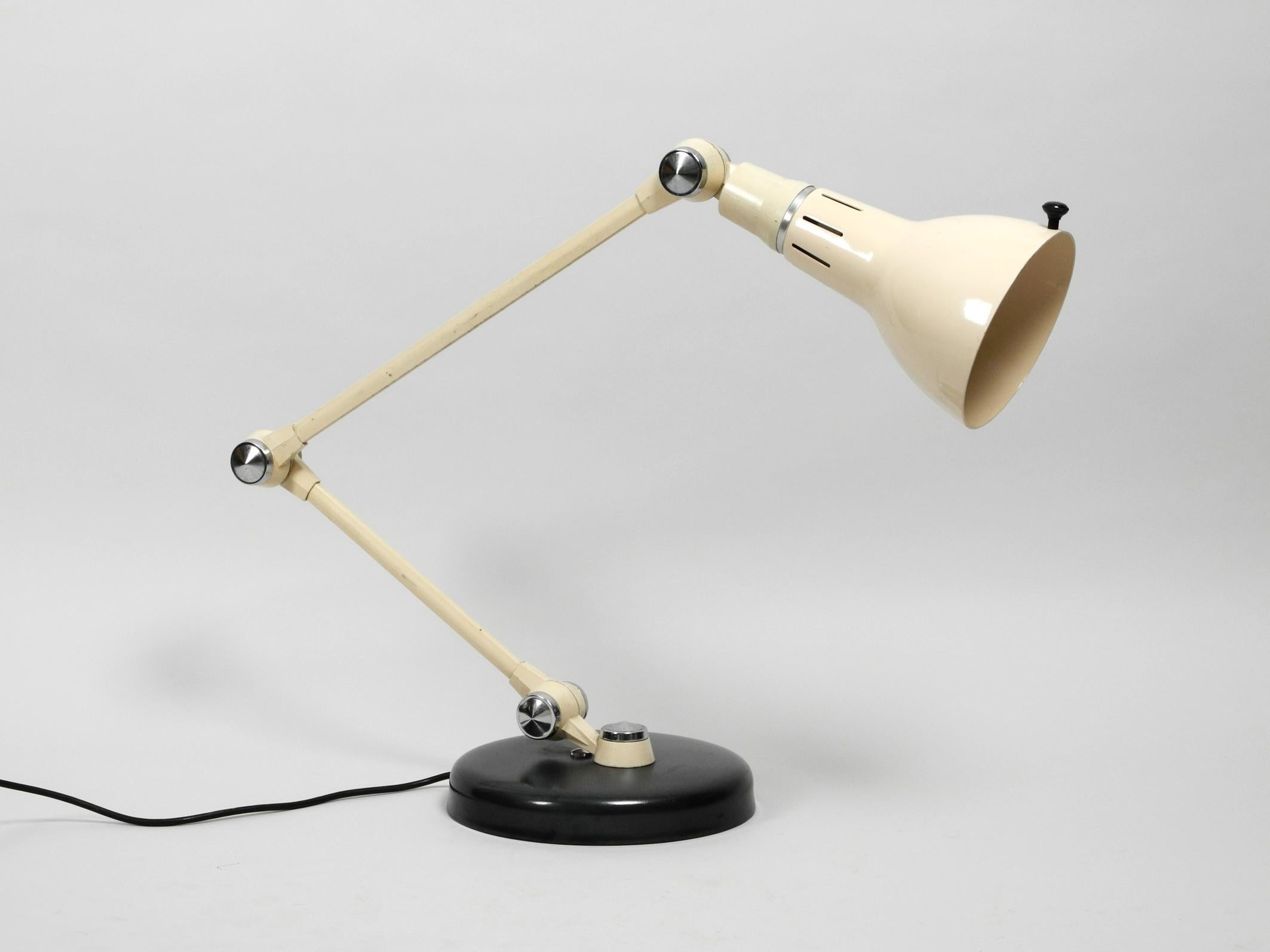 French extra large Mid-Century Modern metal jointed arm table lamp 
with the original beige paint.
Very heavy high-quality model made of solid metal.
According to the previous owner a rare model of Jielde.
With three large joints for adjusting