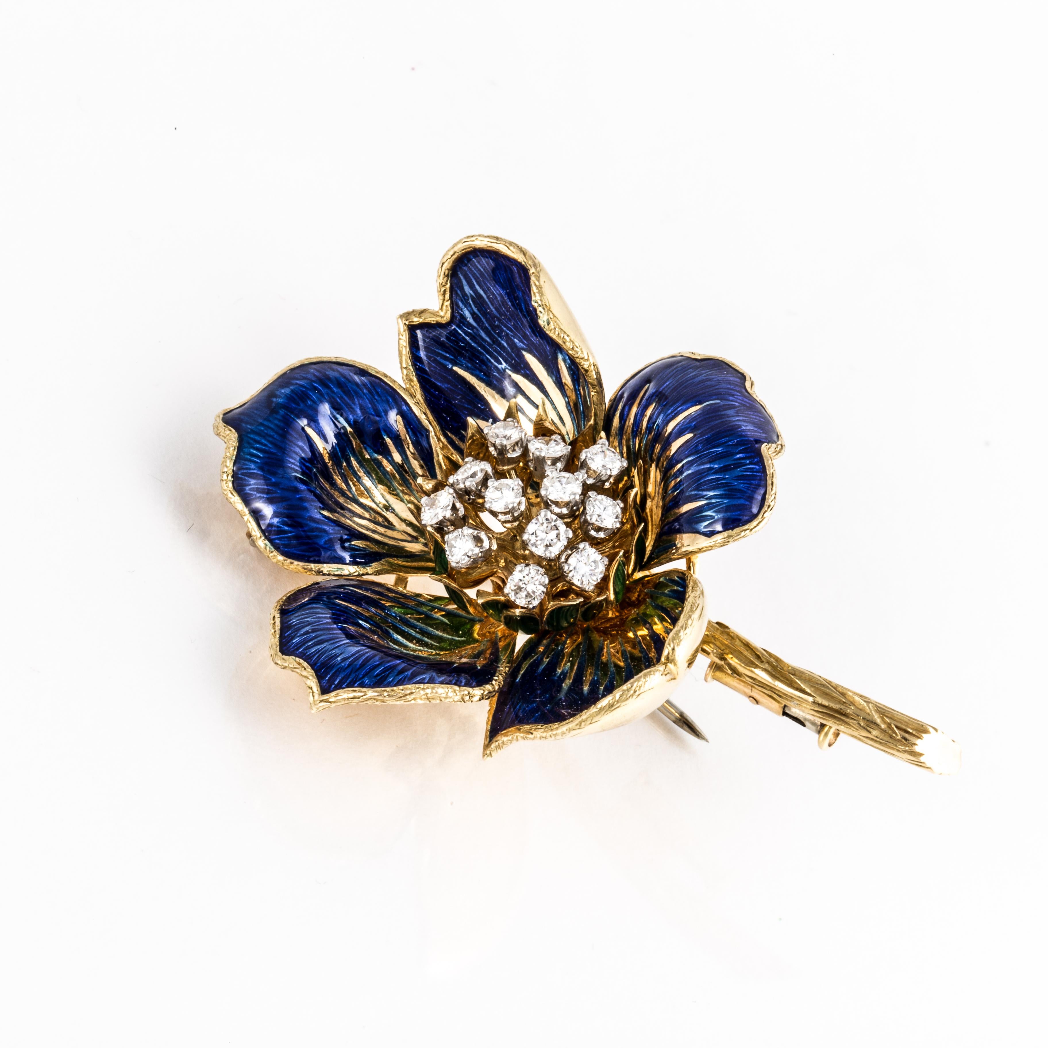 Blue enamel flower brooch in 18K yellow gold with round cut diamonds in the center.  There are 12 round diamonds that total 1.10 carats; G-H color and VS2-SI1 clarity.  Pin measures 2 1/4 inches long and 1 1/2 inches wide.  Closure is a double clip