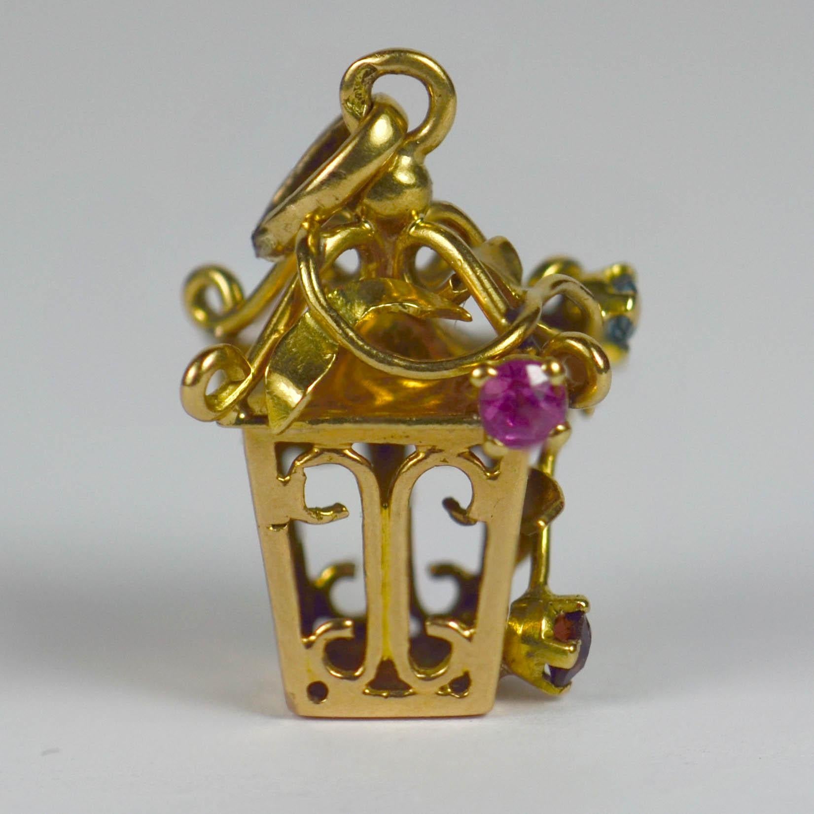 An 18 karat yellow gold French charm pendant designed as a lantern with a climbing gem set vine. Stamped with the eagle's head for French manufacture of 18 karat gold, the vine set with round cut paste stones.

Dimensions: 2 x 1.2 x 1.2 cm
Weight:
