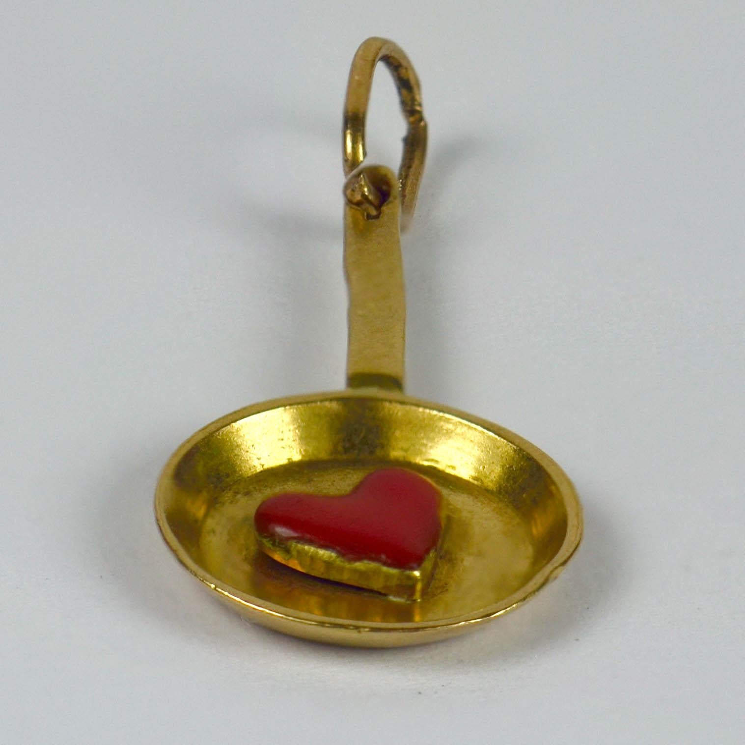 An 18 karat gold French charm pendant designed as a frying pan with a red enamel love heart to the centre. This is a play on words from 'fricassee' meaning at once 'frying' and an 'exchange of kisses'.
Stamped with the French eagles head poincon for