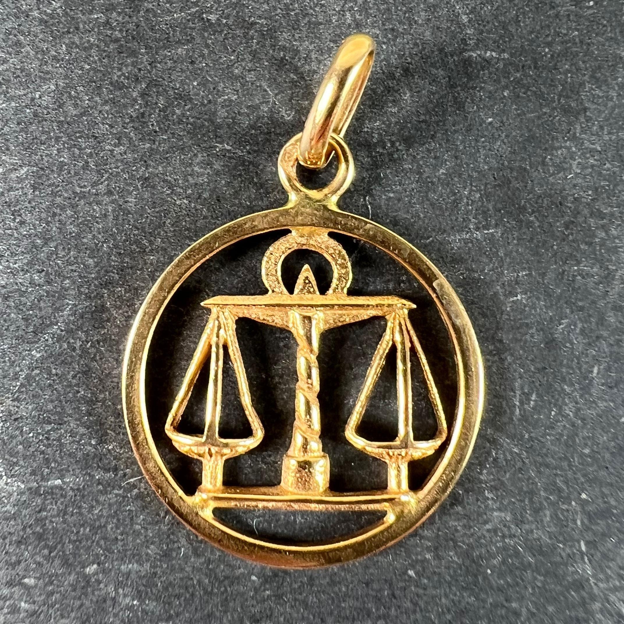 Ciondolo francese vintage in oro giallo 18 carati (18K) a forma di medaglia raffigurante il segno zodiacale della Bilancia, con un paio di bilance. Timbrato con la testa dell'aquila francese per l'oro a 18 carati e un marchio di fabbrica