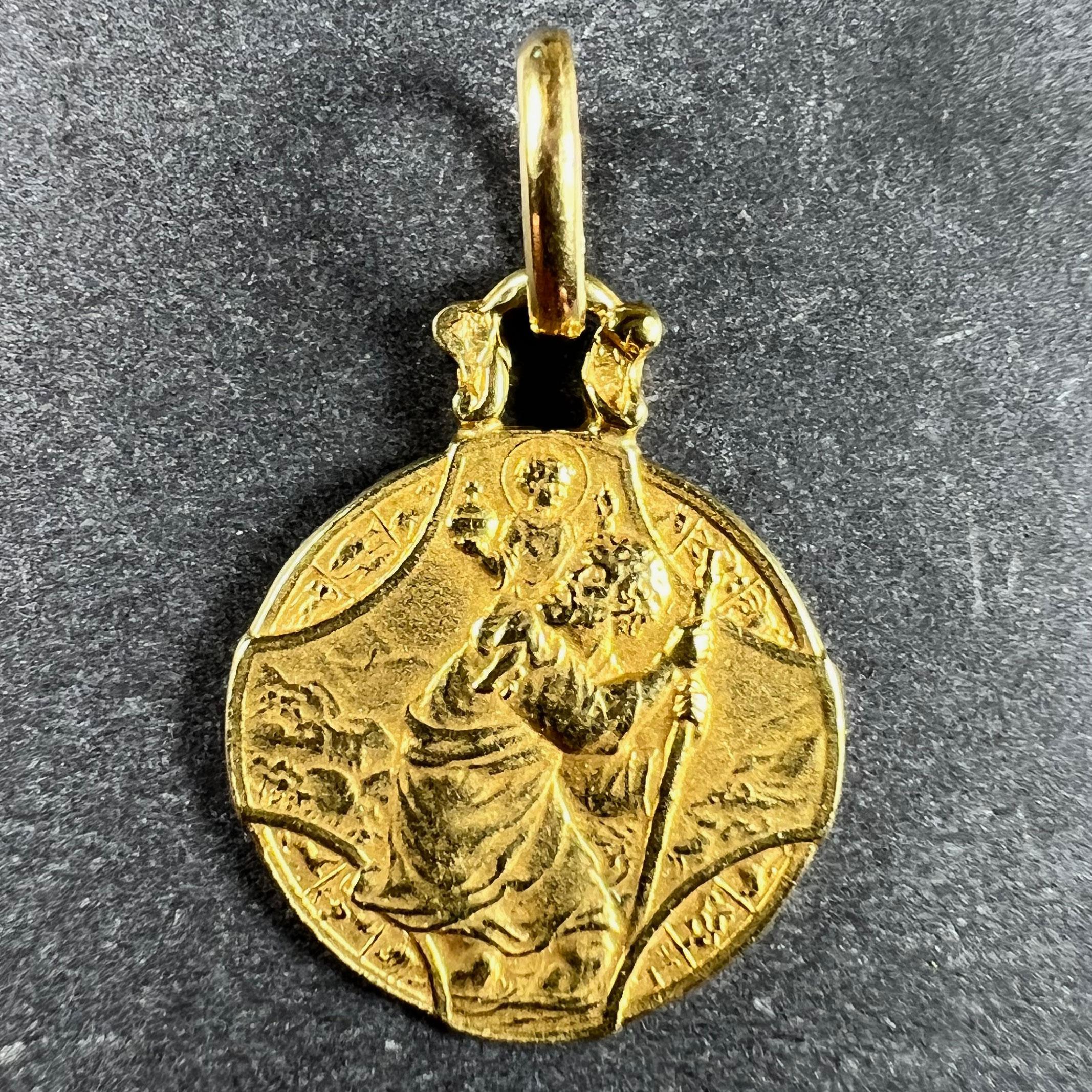 A French 18 karat (18K) yellow gold charm pendant depicting St Christopher as he carries the infant Christ across a river, within a cross shape overlaying a circle depicting the zodiac signs. 

The reverse depicts the Triumph of Speed showing a