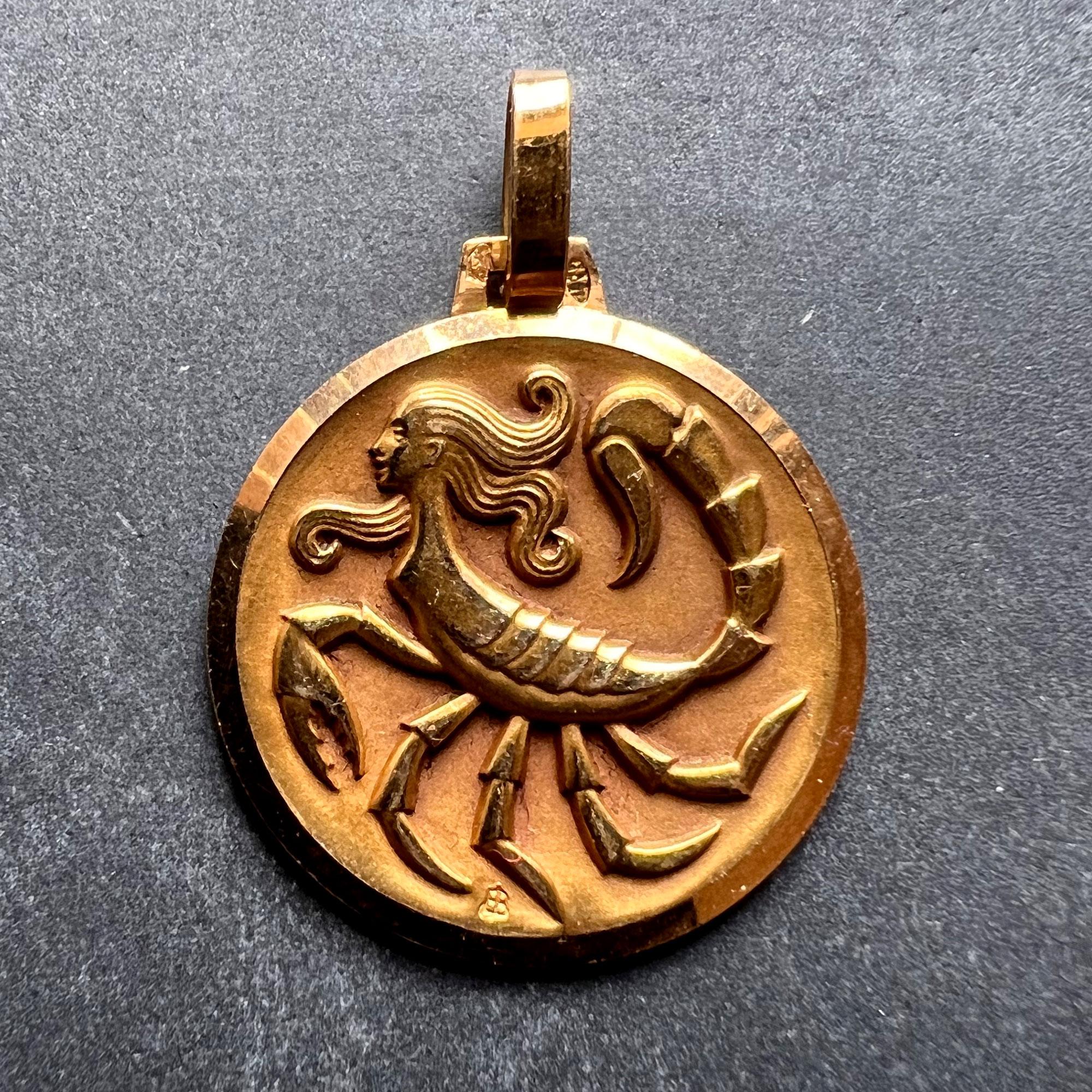 A French 18 karat (18K) yellow gold charm pendant depicting the Zodiac starsign of Scorpio as a mythical creature with the head and upper body of a woman and the lower body of a scorpion. Stamped with the eagles head for French manufacture and 18