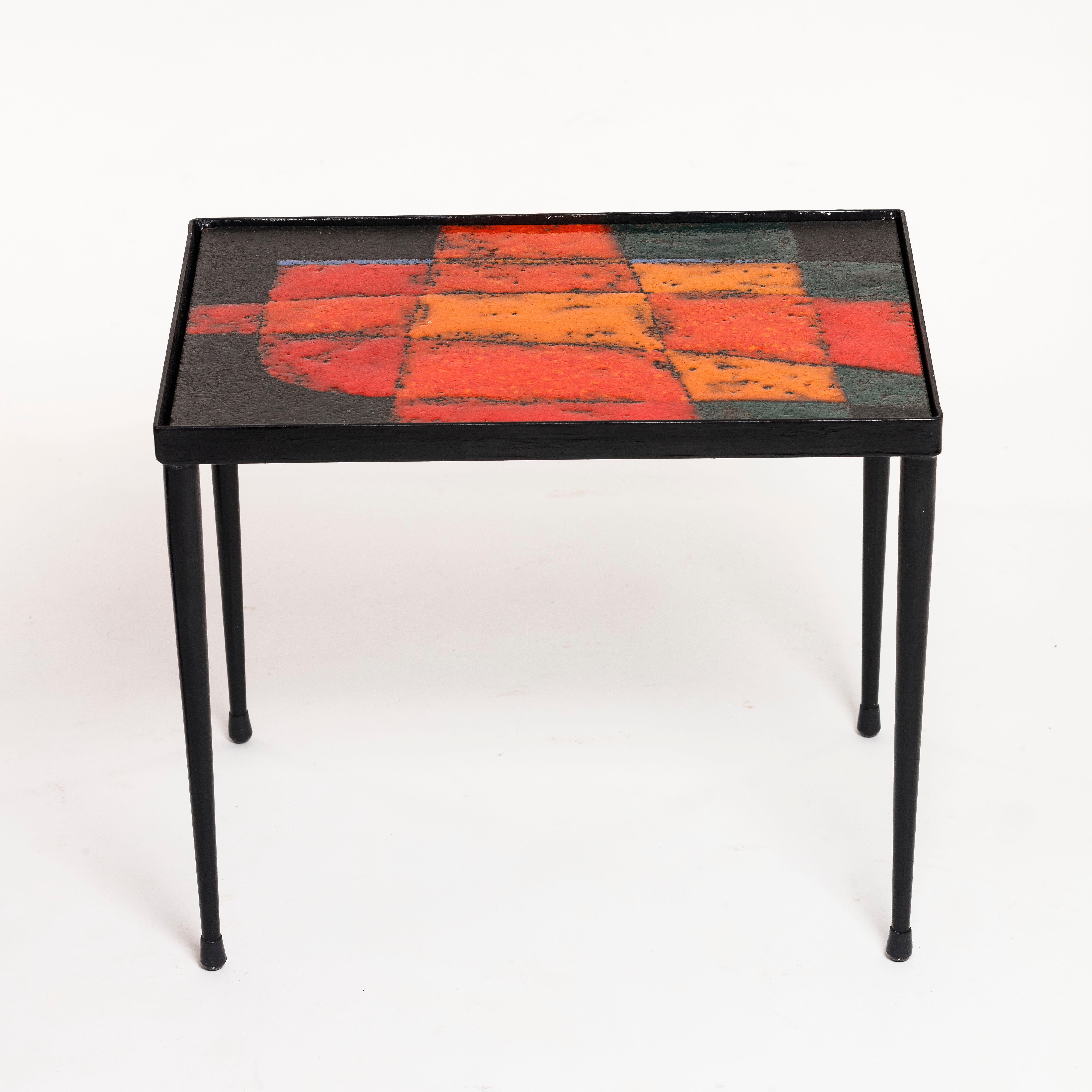 Rare red enameled lava tile low table by Robert and Jean Cloutier dating from the 1950s. This mid-century Lava Tile Coffee Table by the Cloutier Brothers is truly a one-of-a-kind piece.

Beautifully crafted from a black metal base, the rectangular