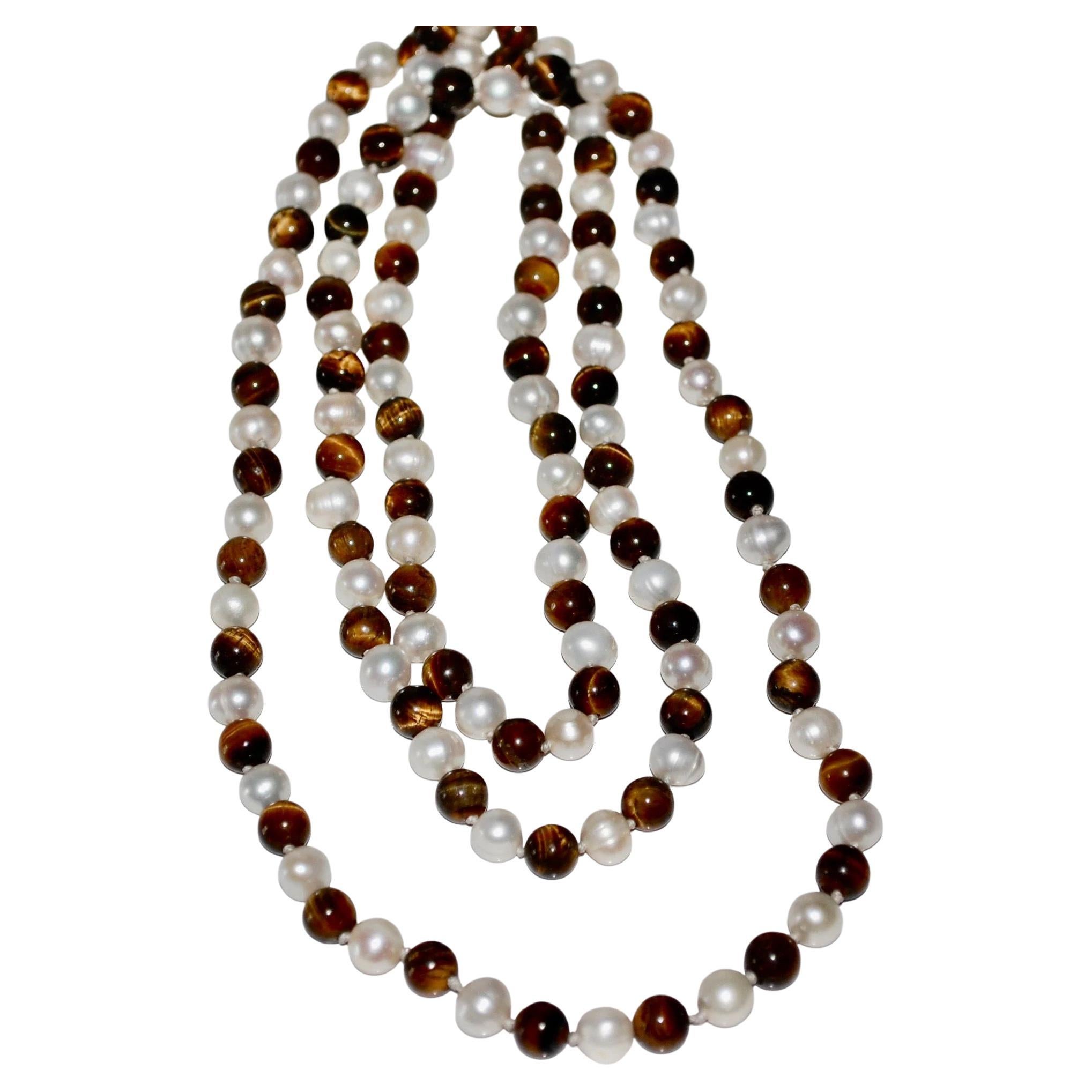 Bellissima collana lunga annodata a mano, con perle bianche tonde naturali d'acqua dolce e perle tonde naturali di occhio di tigre di circa 7 mm.  Lunghezza 24