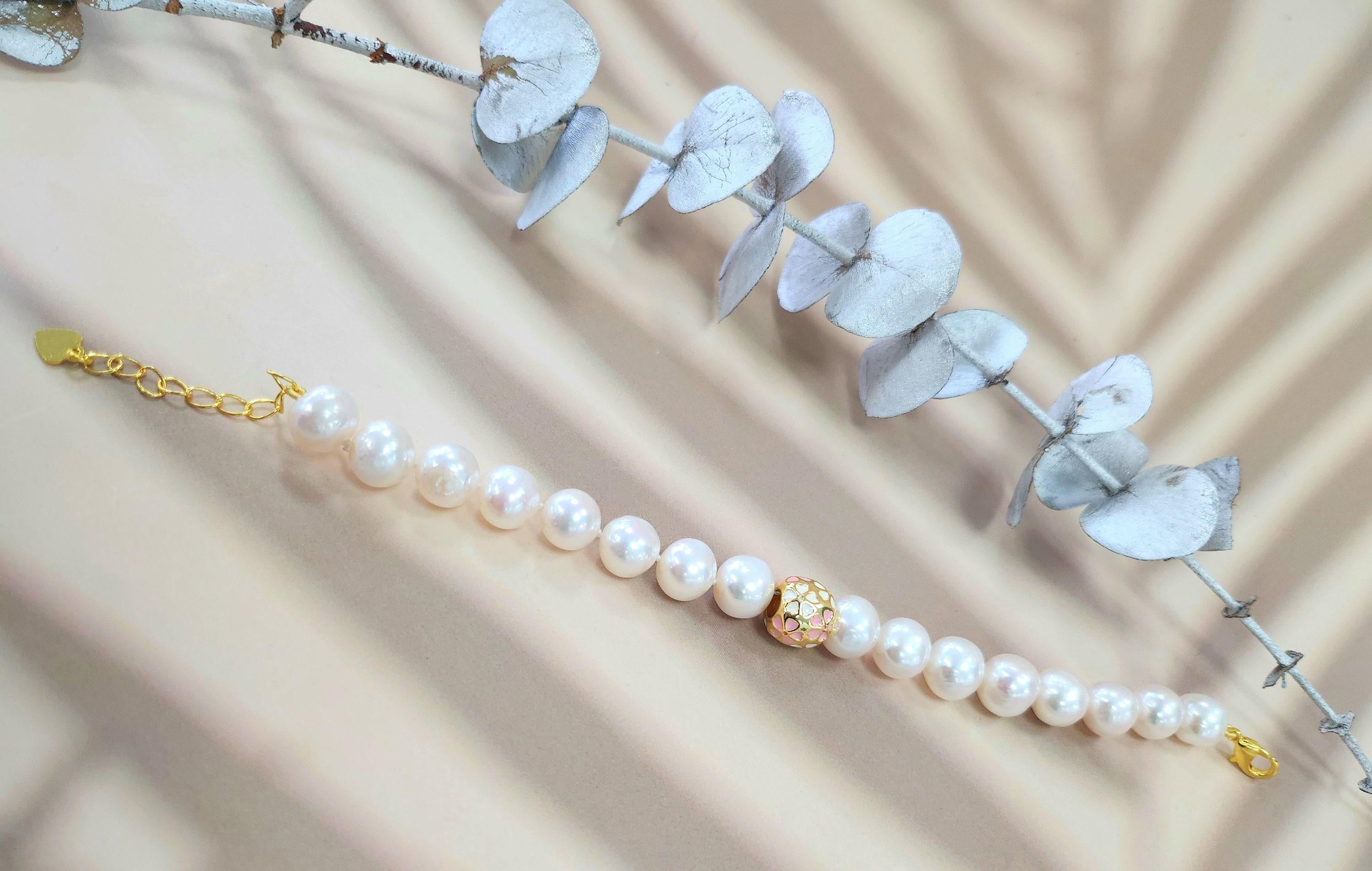 Eleganza delle perle d'acqua dolce e dei fiori di ciliegio - Bracciale con charm d'oro

La bellezza senza tempo incontra un fascino delicato! Questo bracciale di perle d'acqua dolce è caratterizzato da 16 perle luminose (~10 mm ciascuna) e da un