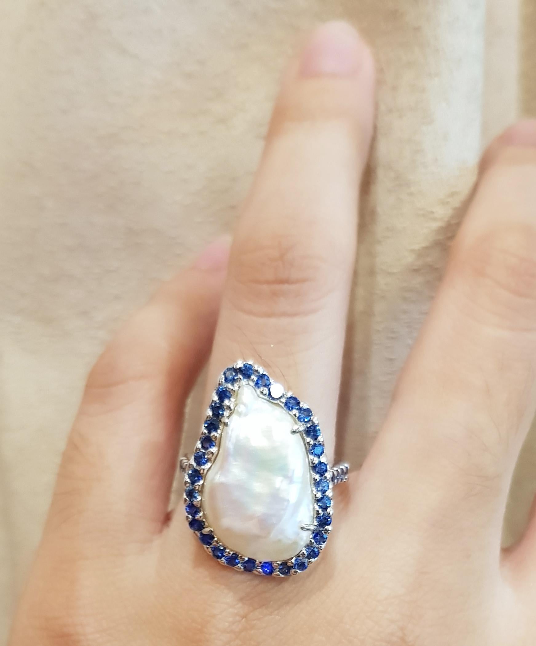 Bague en or blanc 18 carats, perle d'eau douce et saphir bleu 1,03 carats

Largeur :  1.8 cm 
Longueur : 2.3 cm
Taille de l'anneau : 53
Poids total : 7,98 grammes

