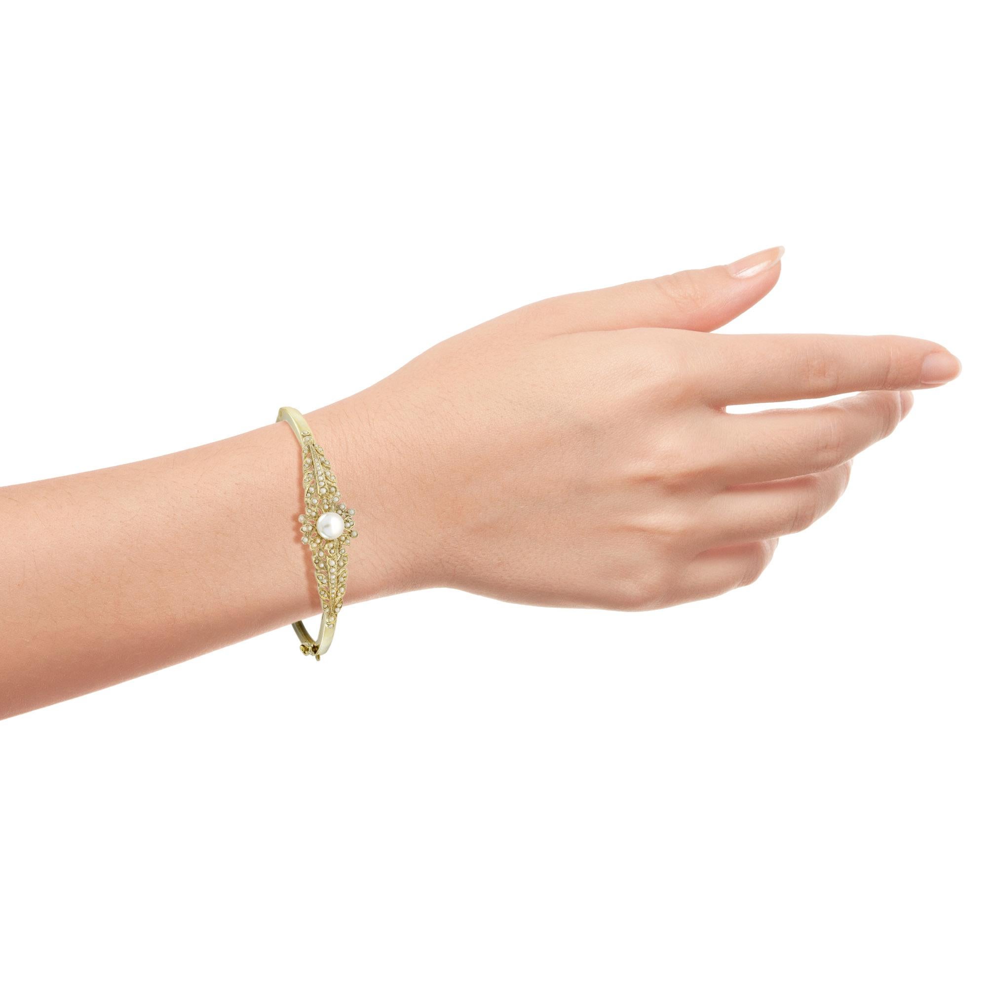 Simply exquisite Victorian era inspired bangle. Hand crafted as unique of solid 14k yellow gold. Charming flower of pearl centered by an approx. 2 carat pearl with further seed pearl chasing the sides. The is the design that a lady of the Victorian
