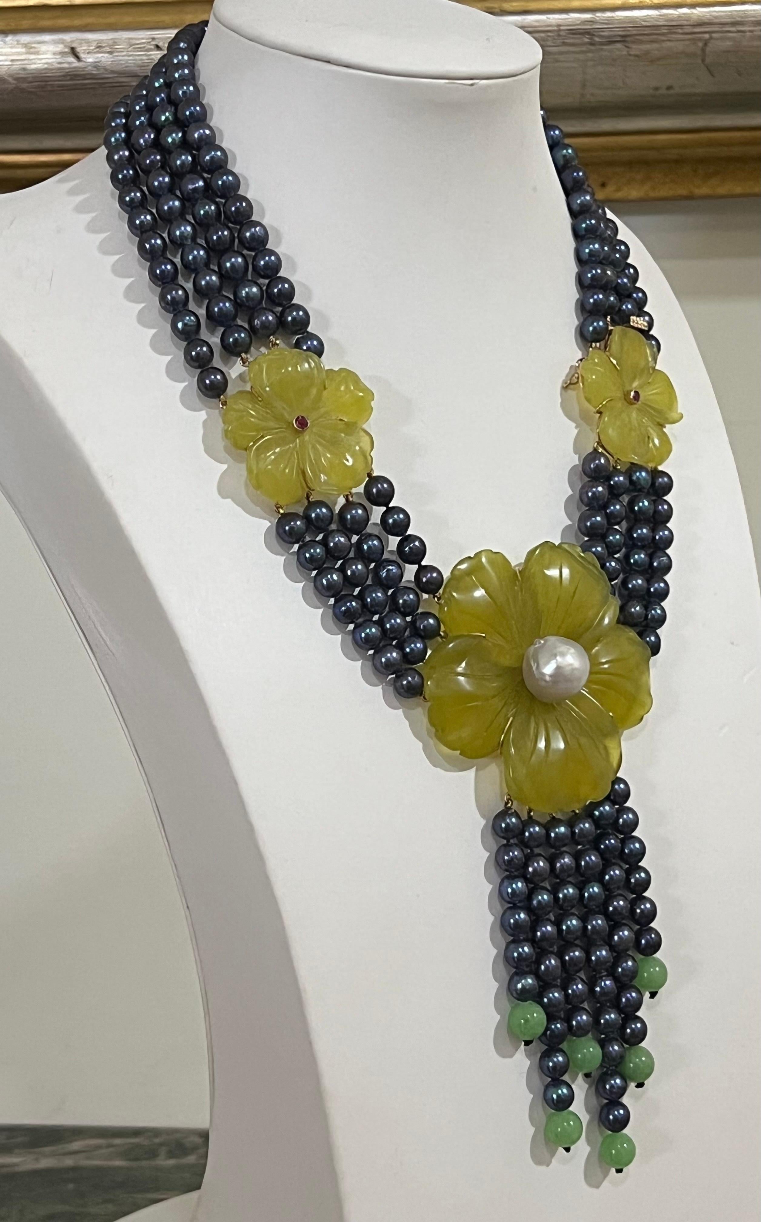 Magnifique collier multibrins composé de perles d'eau douce et entouré de trois fleurs, une centrale plus grande avec une perle au centre et deux fleurs latérales plus petites, dont l'une est le fermoir, la structure qui soutient les fleurs est en