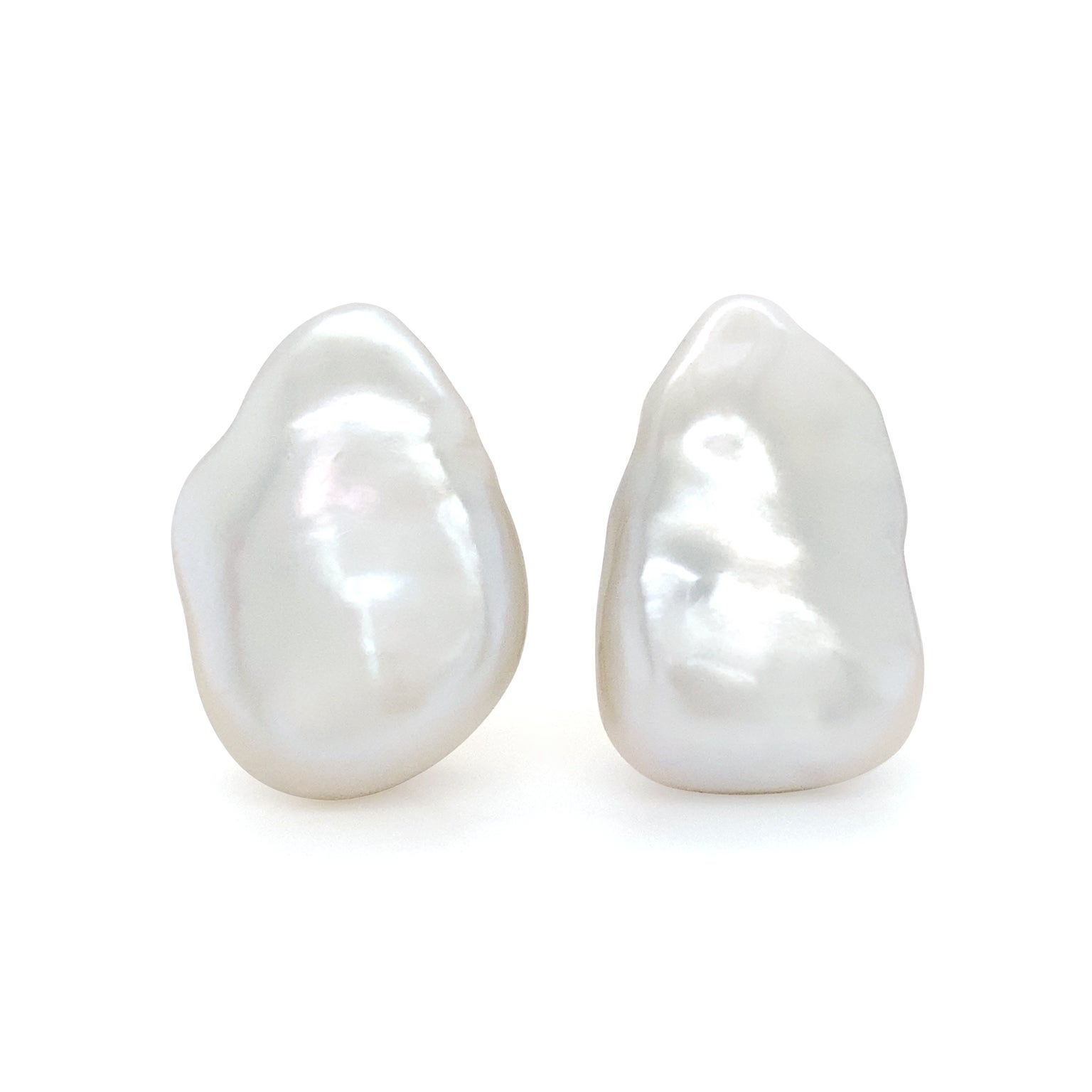 The satin appeal of freshwater pearls are transmitted from these earrings. Light reflects a radiance of silk as delicate shadows are produced in the valleys. Each baroque pearl is set in 18k yellow gold and features subtle differences from its
