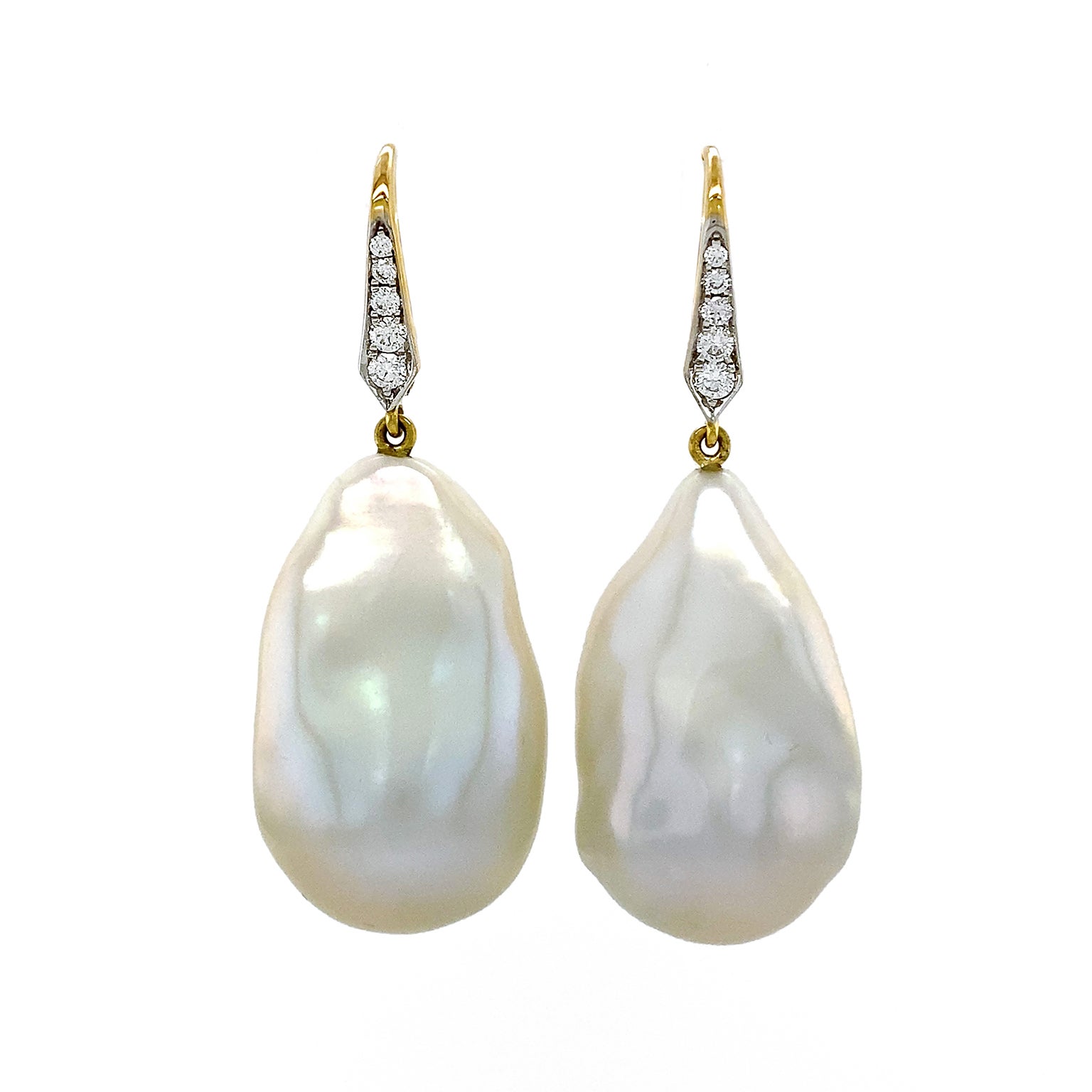 Glowing golden shades are released by these earrings. 18k yellow gold lever backs ornamented with brilliant cut diamonds secure an irregular shaped freshwater pearl. As the light falls on the ivory nacre bodies of the pearls, a unique satin