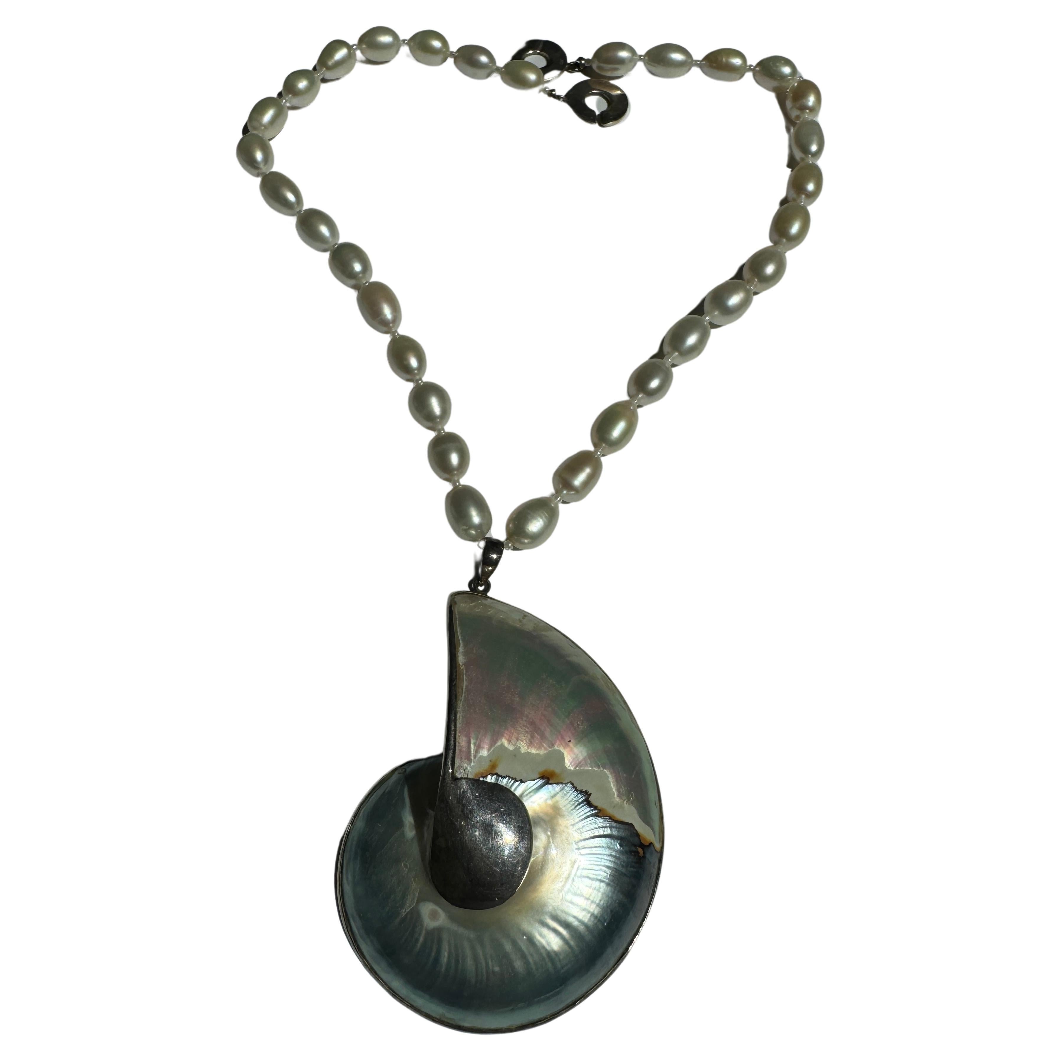 Freshwater oval pearl necklace with natural sea shell pendant in sterling silver.
Handmade one of a kind delicate natural white luster oval pearls, large and natural sea shell pendant, sterling silver round clasp. About 18