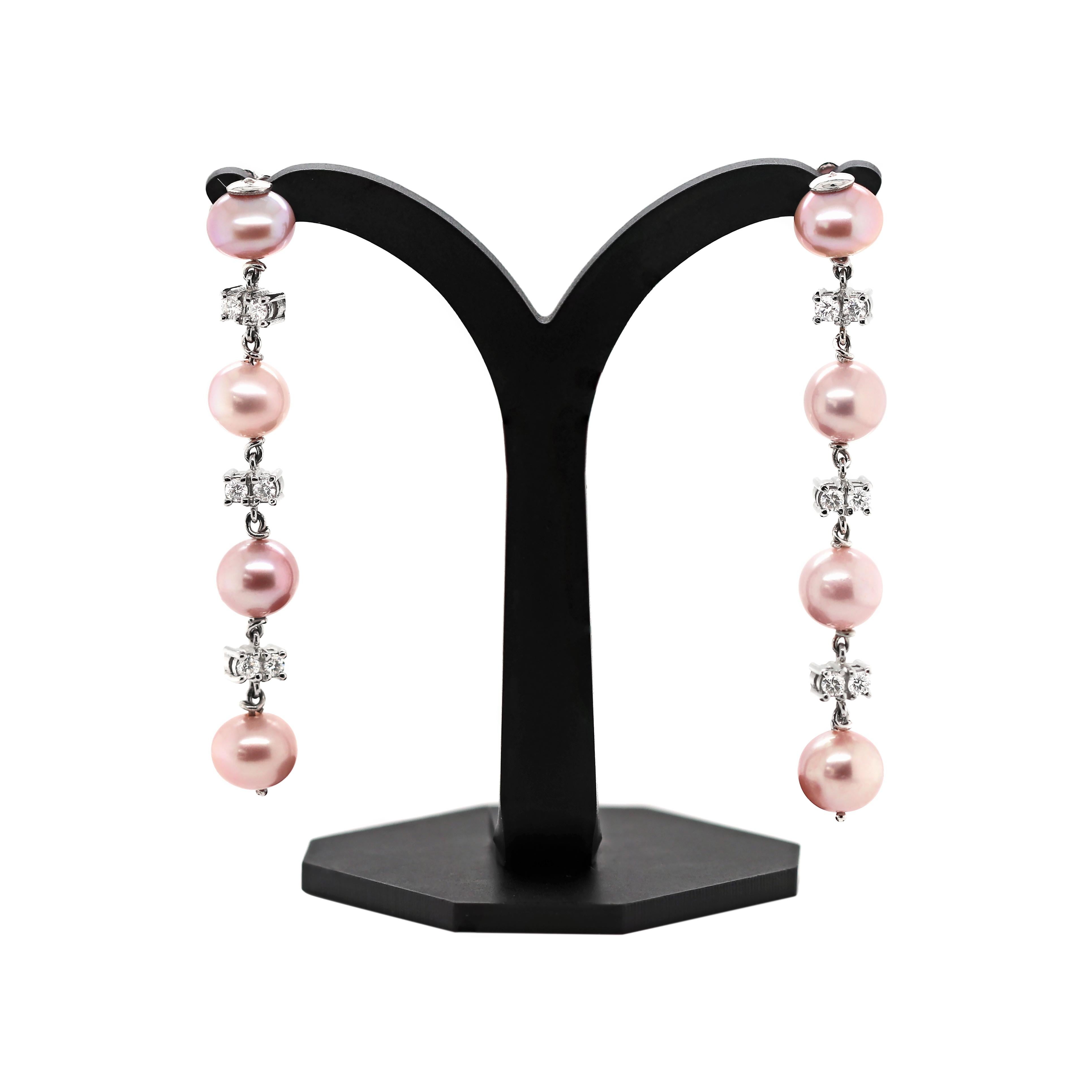 These elegant earrings feature four round rosé coloured freshwater pearls in each. The pearls are beautifully accompanied by six round brilliant cut diamonds, two in between each pearl, mounted in four claw open back settings. The total combined