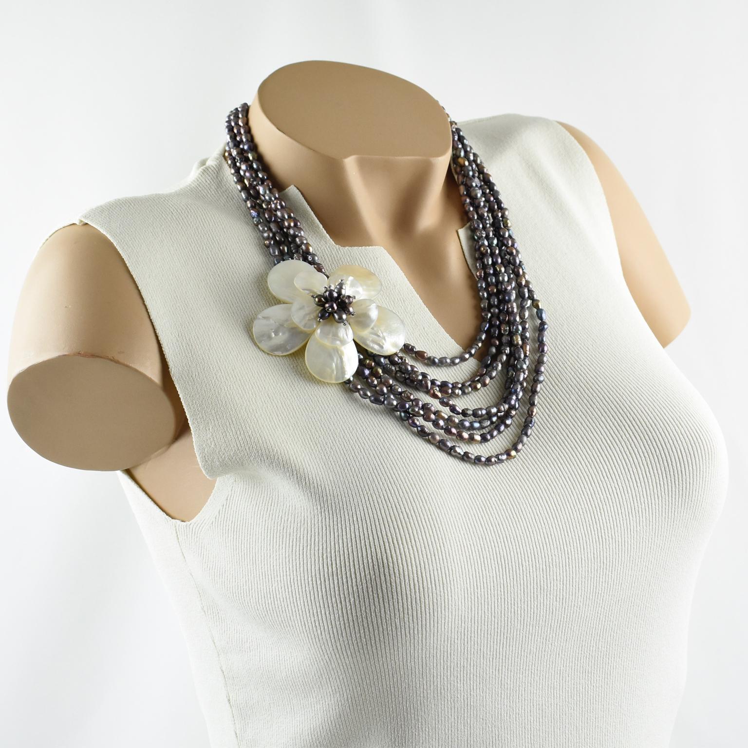This stunning choker necklace features multi-strand freshwater pearl beads complimented with a floral pendant medallion. The freshwater rice pearls have lovely shimmery gray, black, and smoky pink colors. The central pendant, worn on the side, is