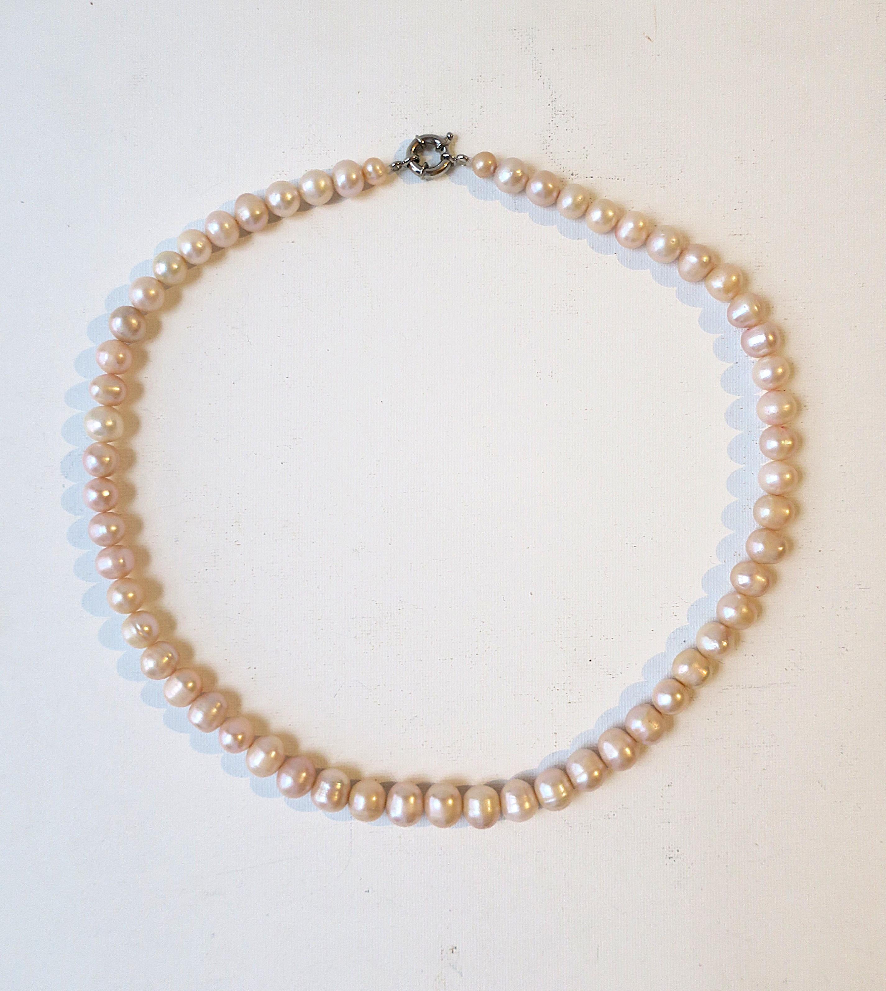 A freshwater pearl bead necklace with a light pink hue shimmer. Dress up or down. Pearls are a nice size, largest measuring 11.17mm. Necklace length: 21.75