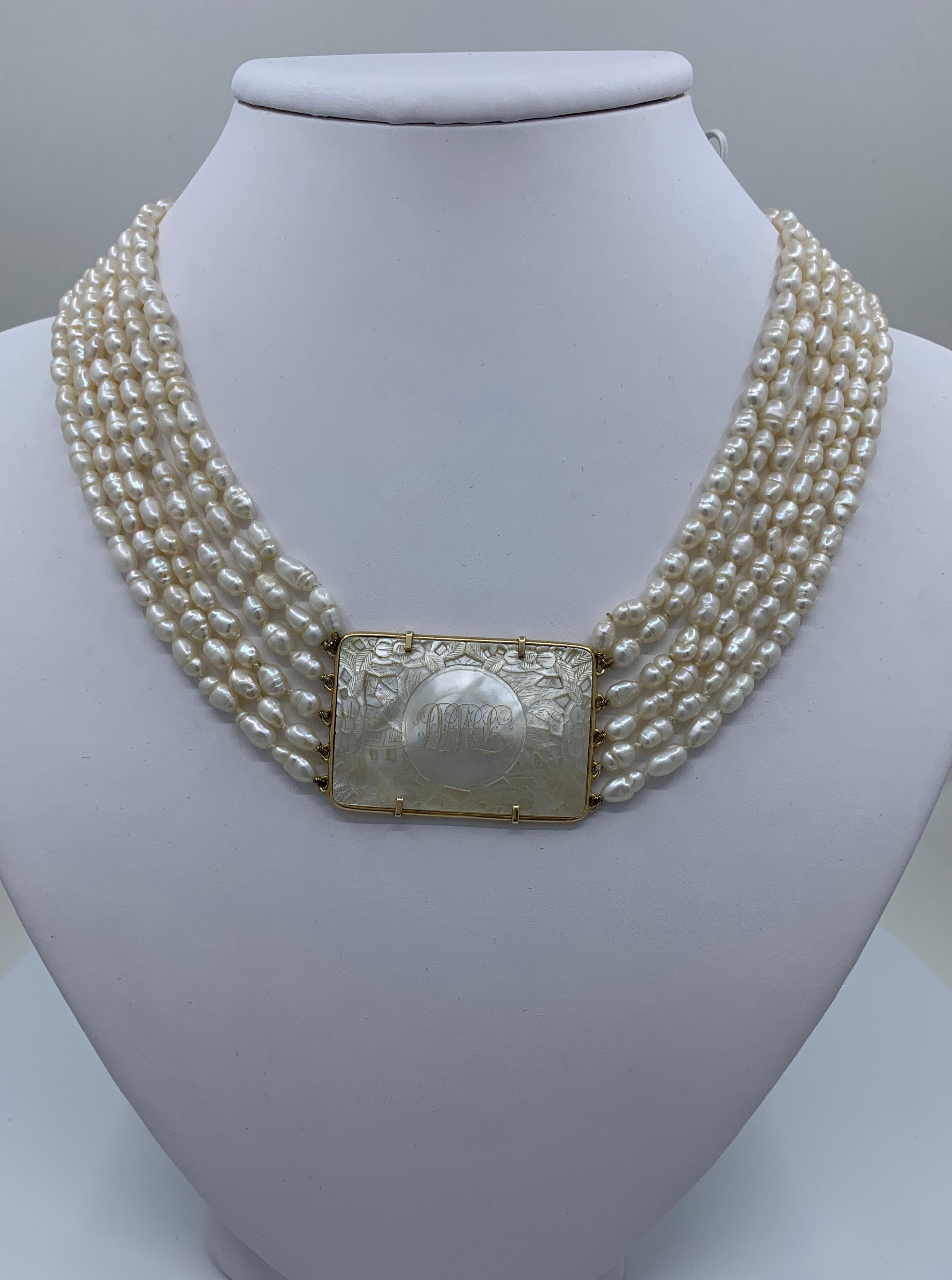 Gorgeous estate 6 strand freshwater pearl choker necklace features a rectangular antique Chinese mother of pearl gambling chip, bezel set in 14 karat yellow gold and fastened with an elegant, large oval, lattice patterned, Florentine finish tongue