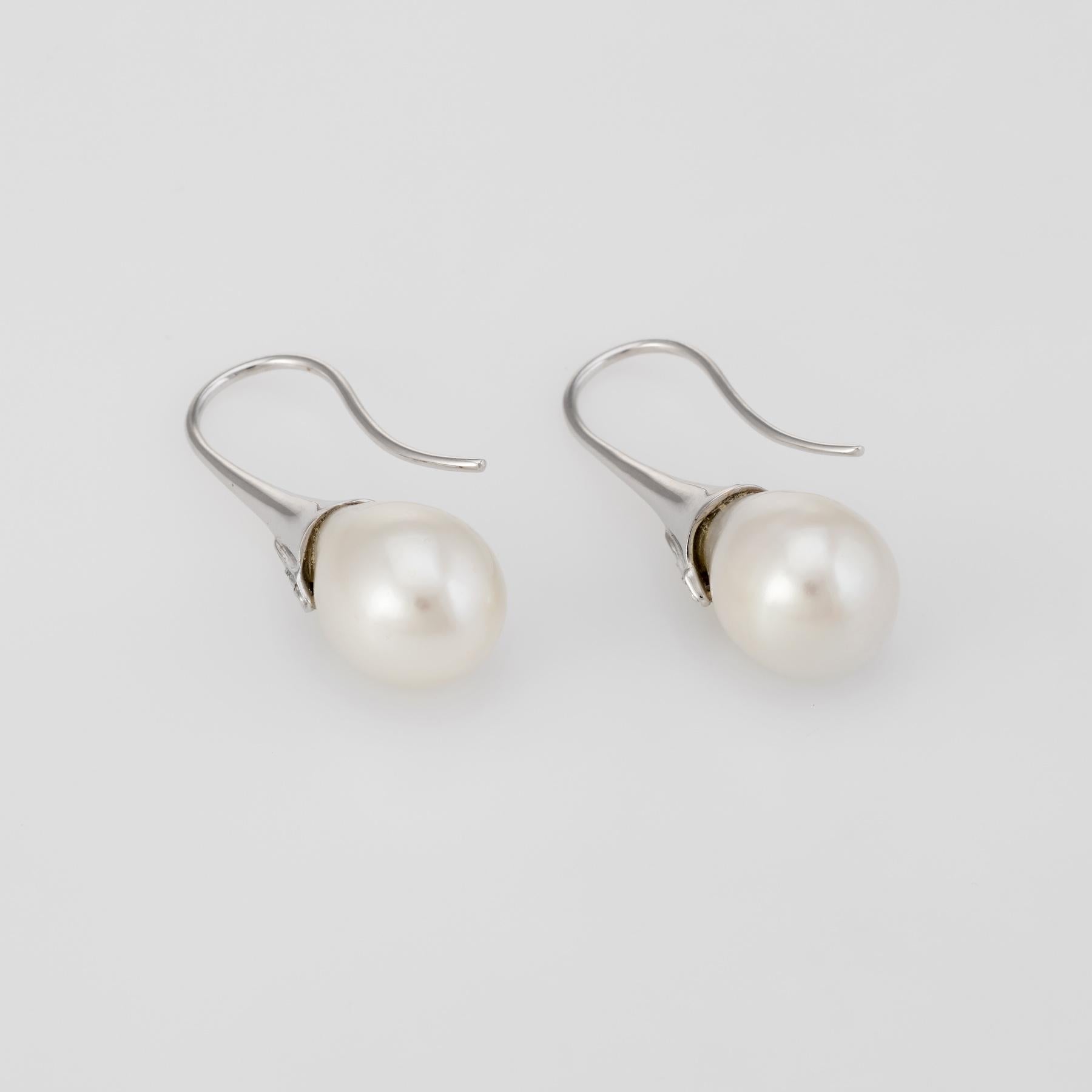 Elegant pair of freshwater pearl & diamond earrings, crafted in 18k white gold. 

Freshwater pearls each measure 9.5mm, accented with an estimated 0.02 carats of diamonds (estimated at I color and I1 clarity).

The earrings feature hook