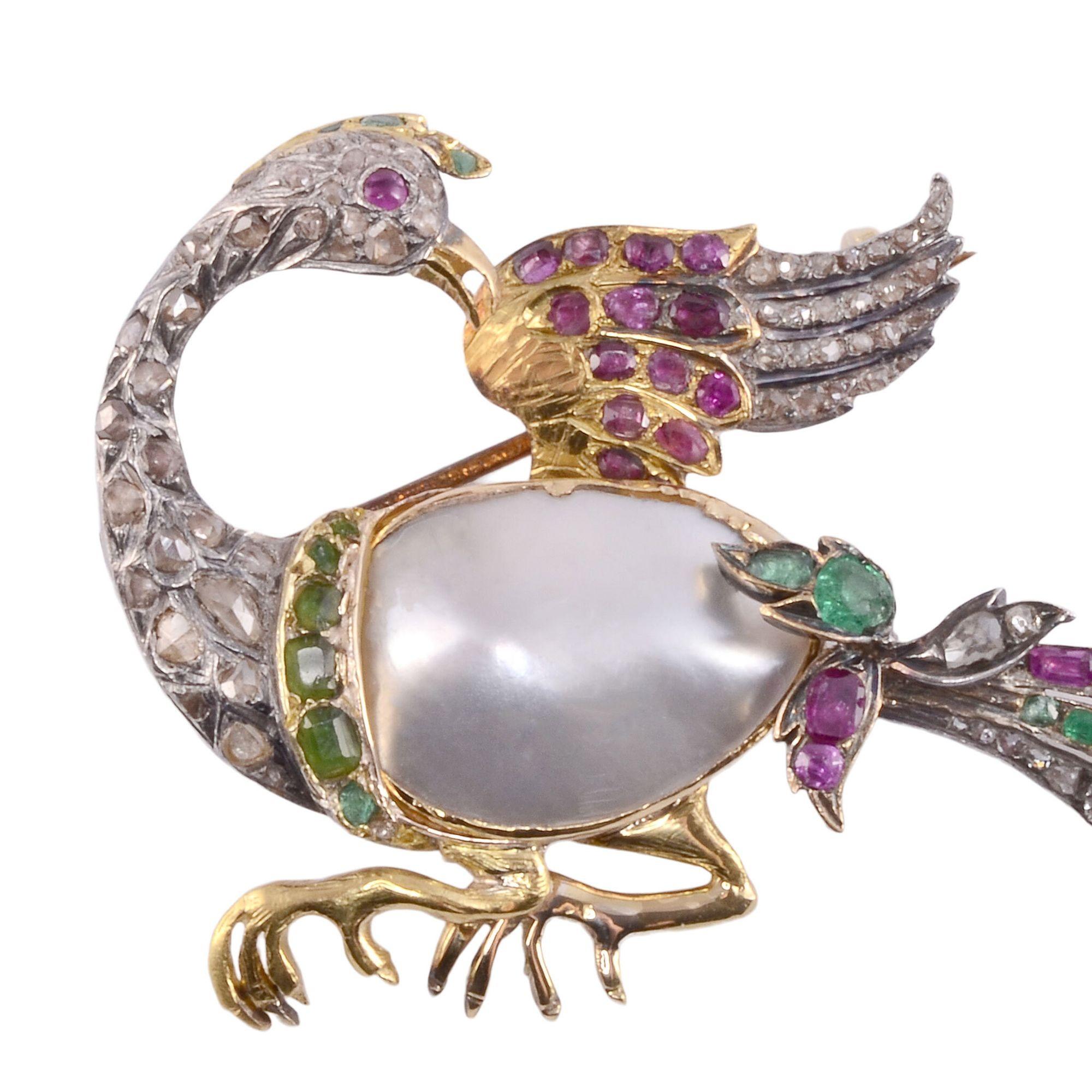 Antique freshwater pearl, emerald, pink sapphire & diamond bird brooch, circa 1890. This 22 karat gold, 9 karat gold, and sterling silver bird brooch features a large freshwater pearl body accented with emeralds, pink sapphires, diamonds, and green