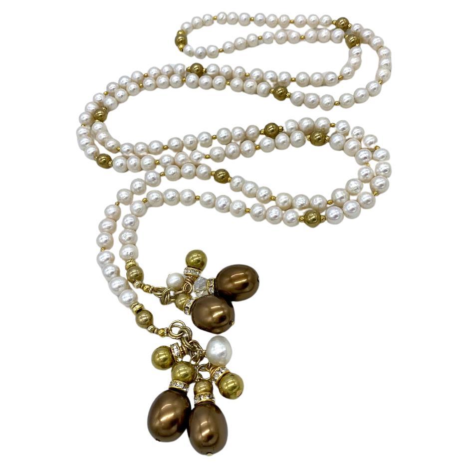 This is a freshwater pearl long strand necklace. Nouveau Boutique recently created it with average 8mm freshwater cultured pearls and 8mm brass beads. On both ends are 3 inch linked dangling charms. The 53 inch strand of pearls could confortably go