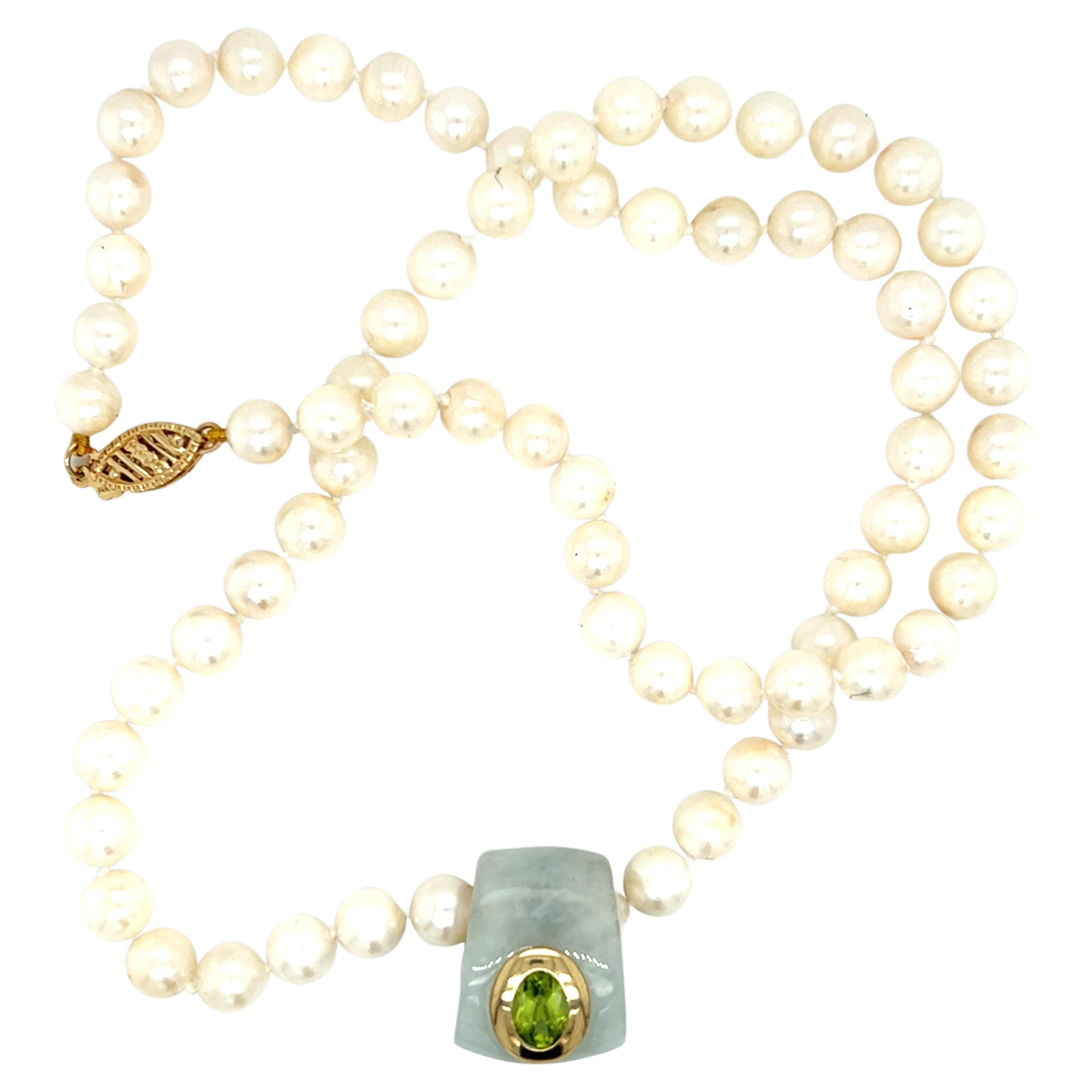 One freshwater pearl strand necklace set with 11mm freshwater pearls and one 19.2x22.68mm jade slide pendant, set with one oval peridot stone, measuring 11.7x9.7mm, surrounded by a 14 karat yellow gold bezel.  The necklace measures 18.5 inches long